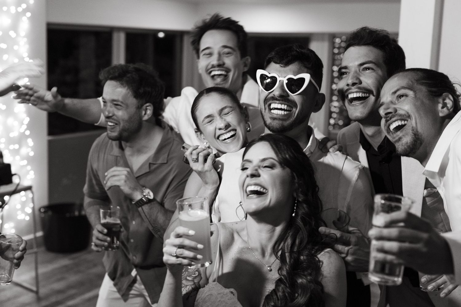 Guests laugh and celebrate joyfully during a wedding reception.