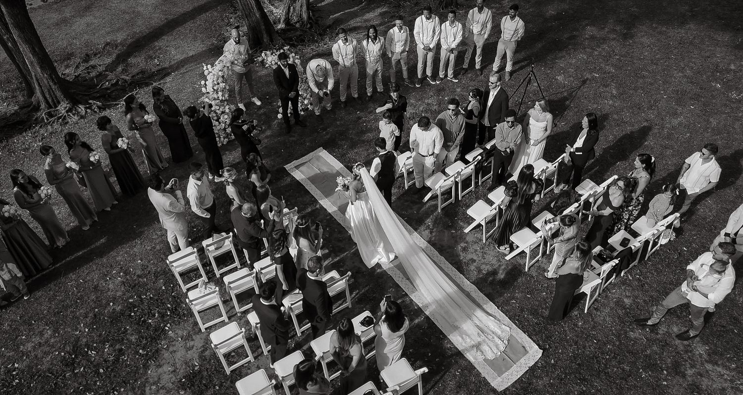 Aerial black and white view of wedding ceremony seating arrangement with guests.