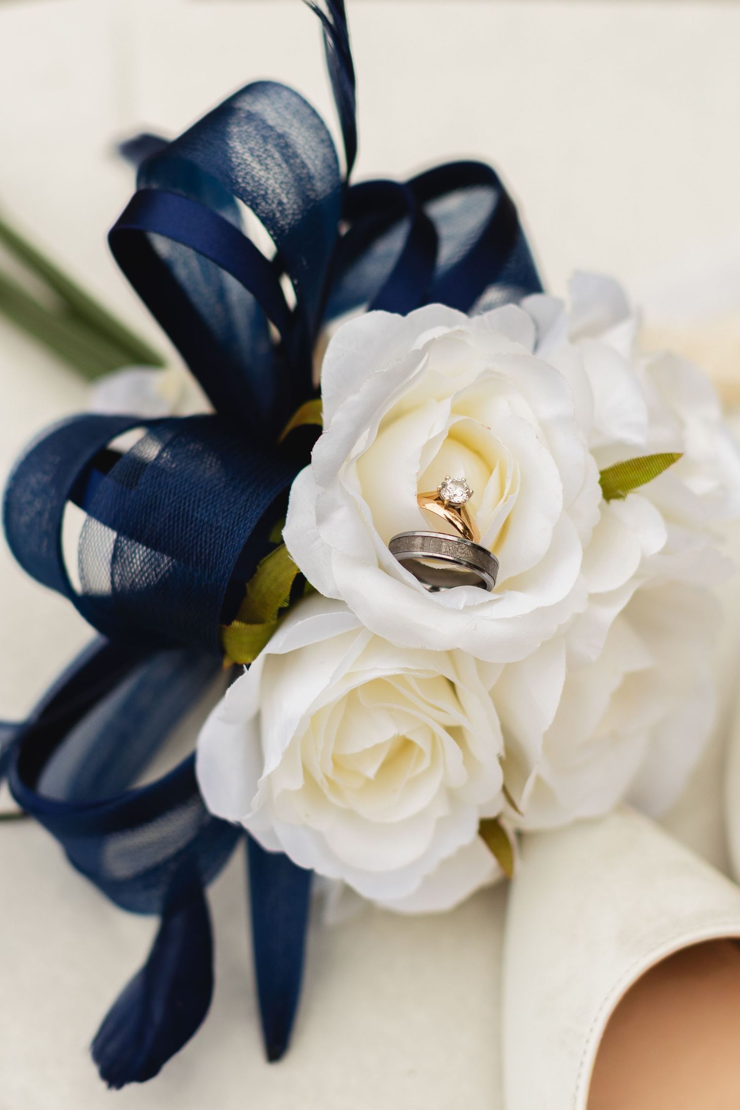 Close-up of elegant wedding corsages featuring white roses and navy blue flowers arranged in a delicate pattern.