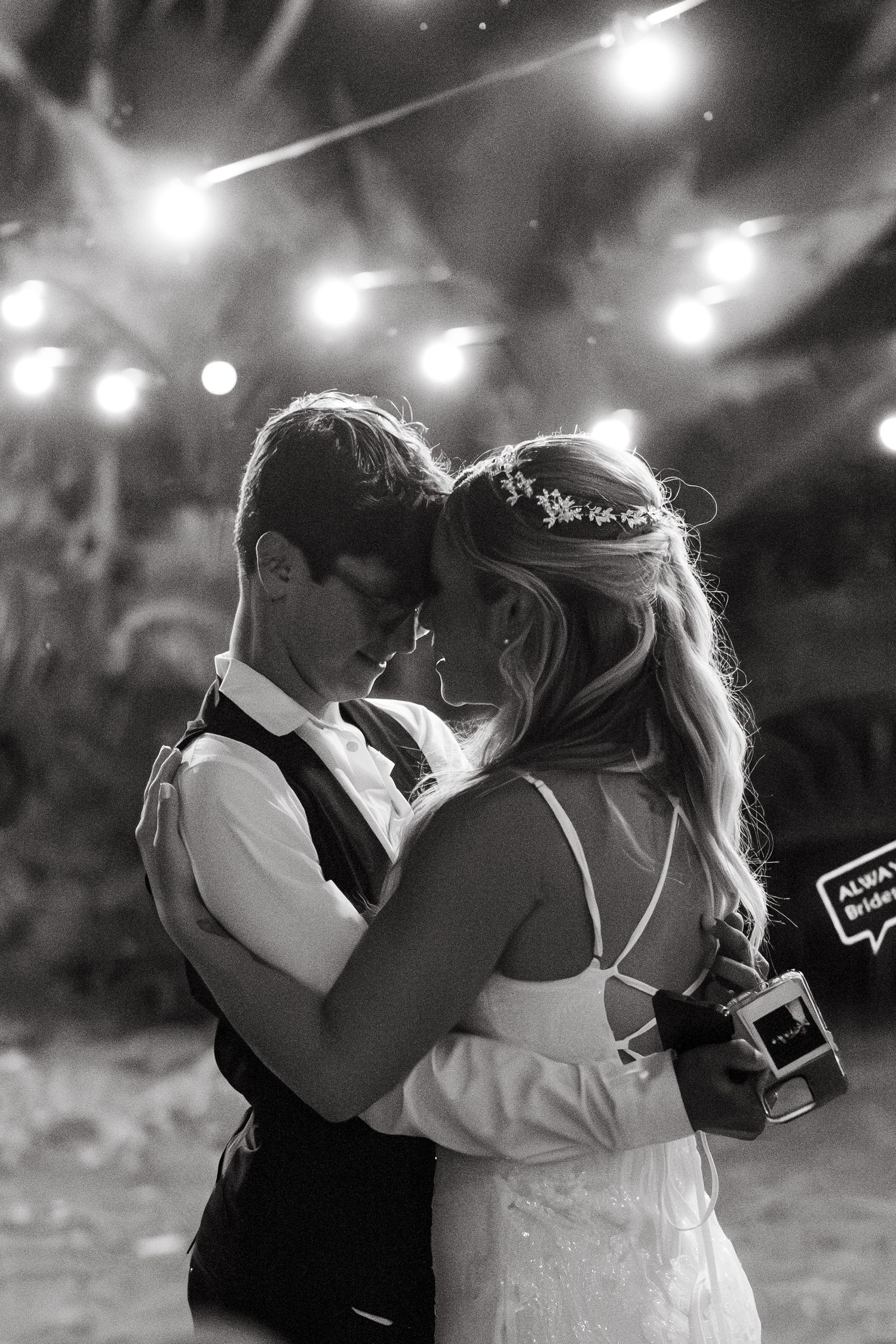 Black and white photo sequence showing a romantic dance moment under twinkling lights.