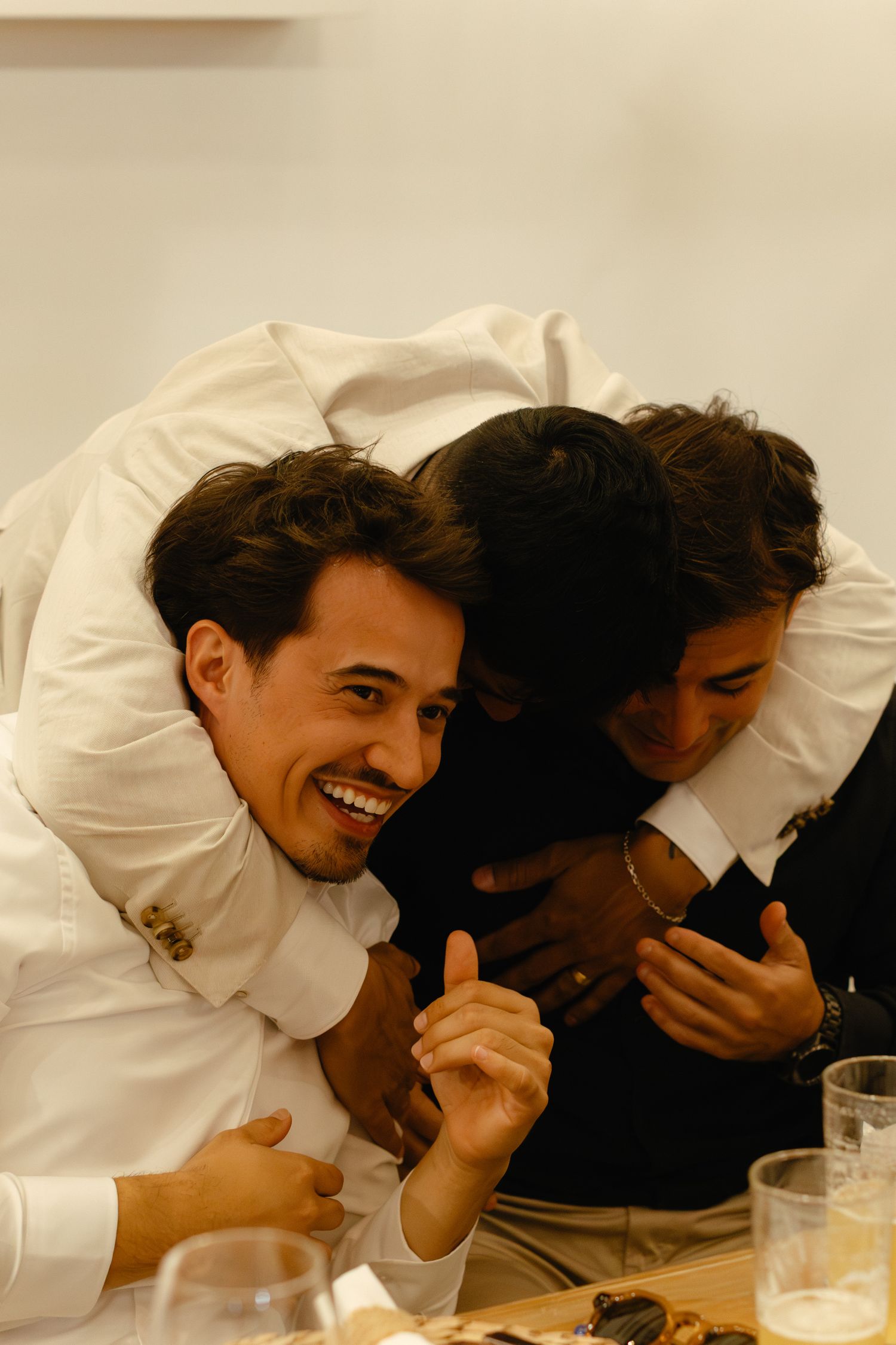 Candid moment of guests laughing together at formal dinner event.