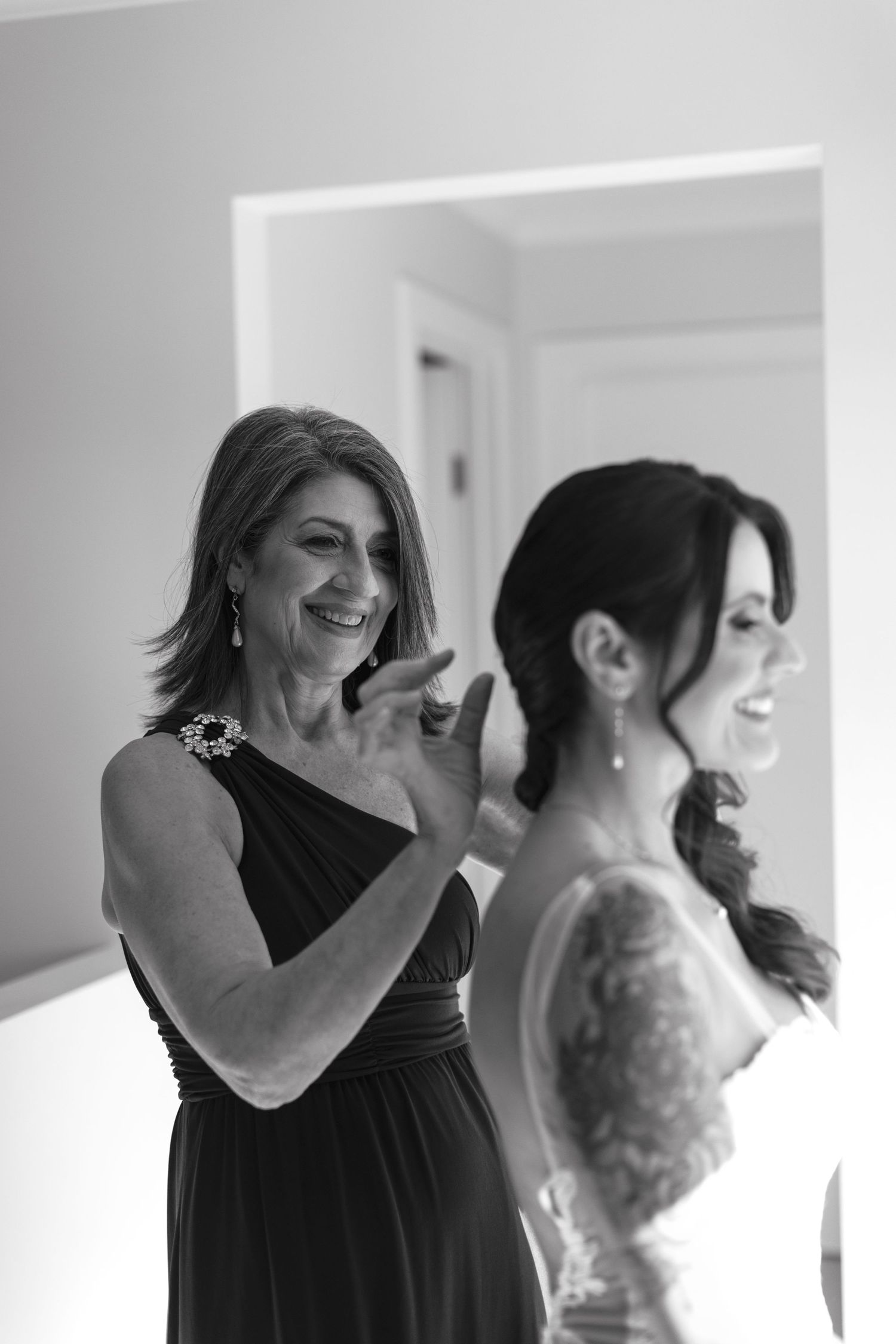 Black and white candid photos show joyful moments of women getting ready together and sharing laughter.