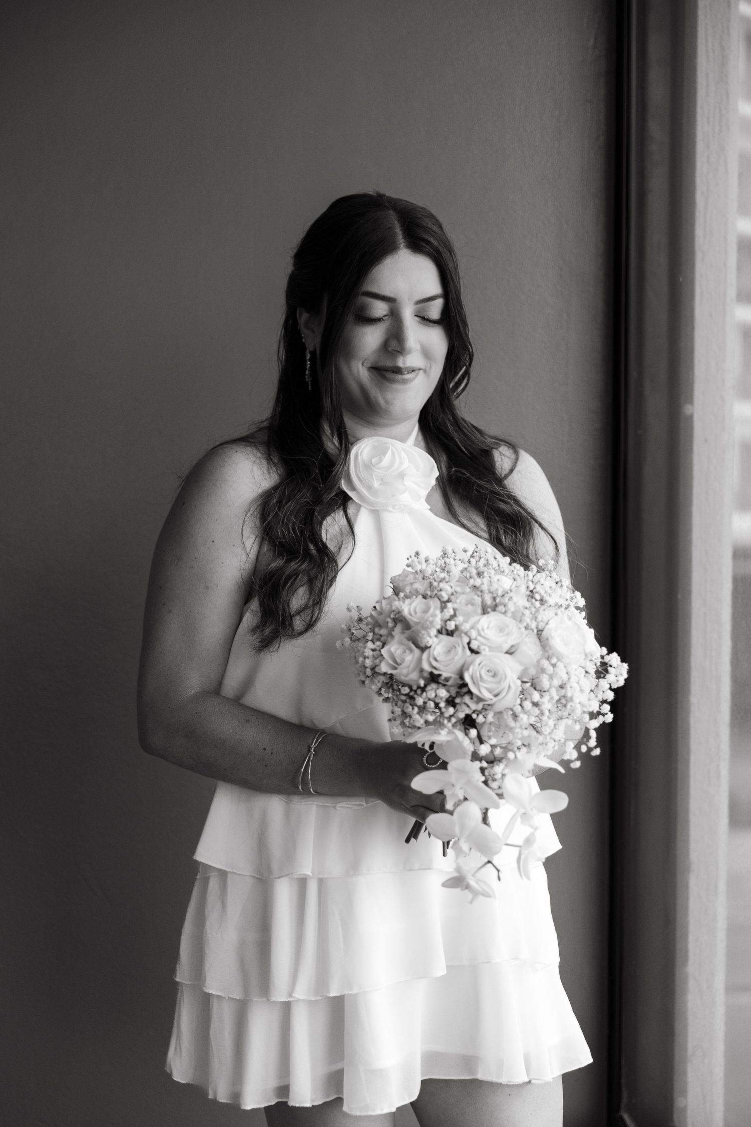 A series of black and white photos shows a figure in a white ruffled dress holding a bouquet of white flowers.