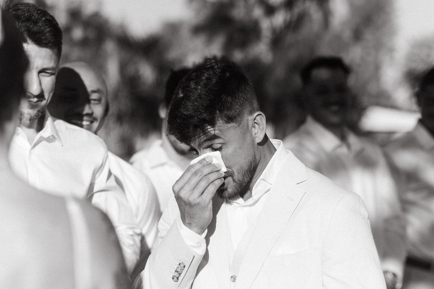 Emotional black and white wedding photography capturing candid reactions and tears of joy.