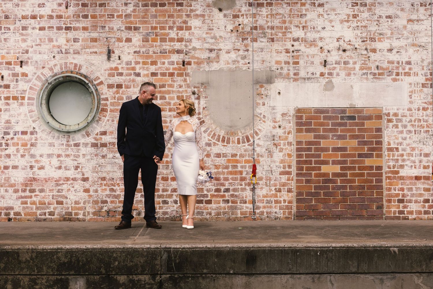 A series of four photos showing a rustic brick wall background with people posing in casual attire.