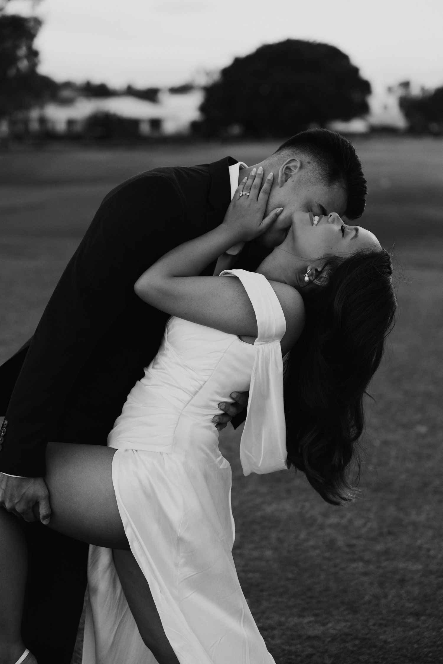 A black and white photo series shows a person in a white top bending backwards gracefully in an outdoor setting.