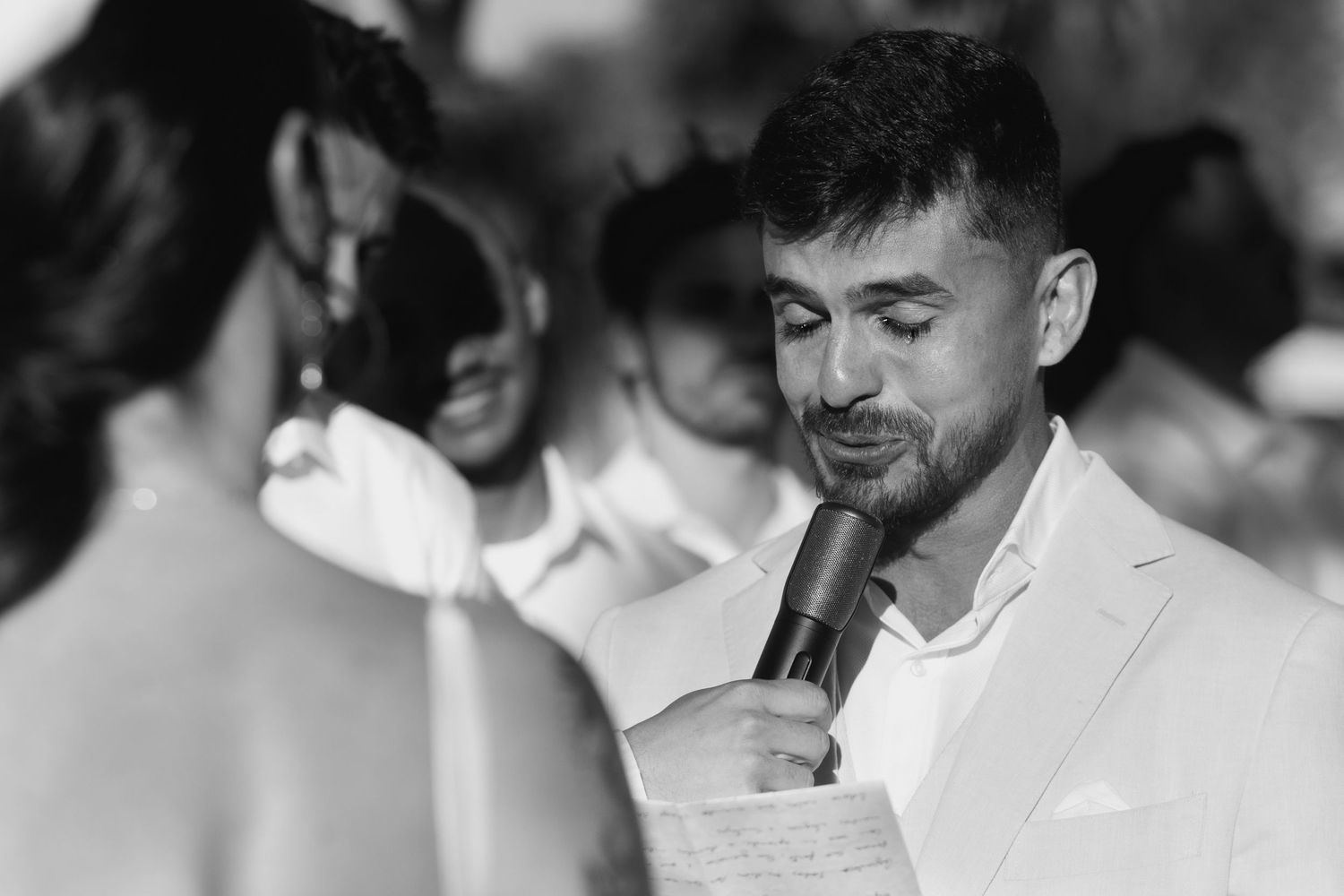 Black and white photo of guests showing emotional reactions at an event.
