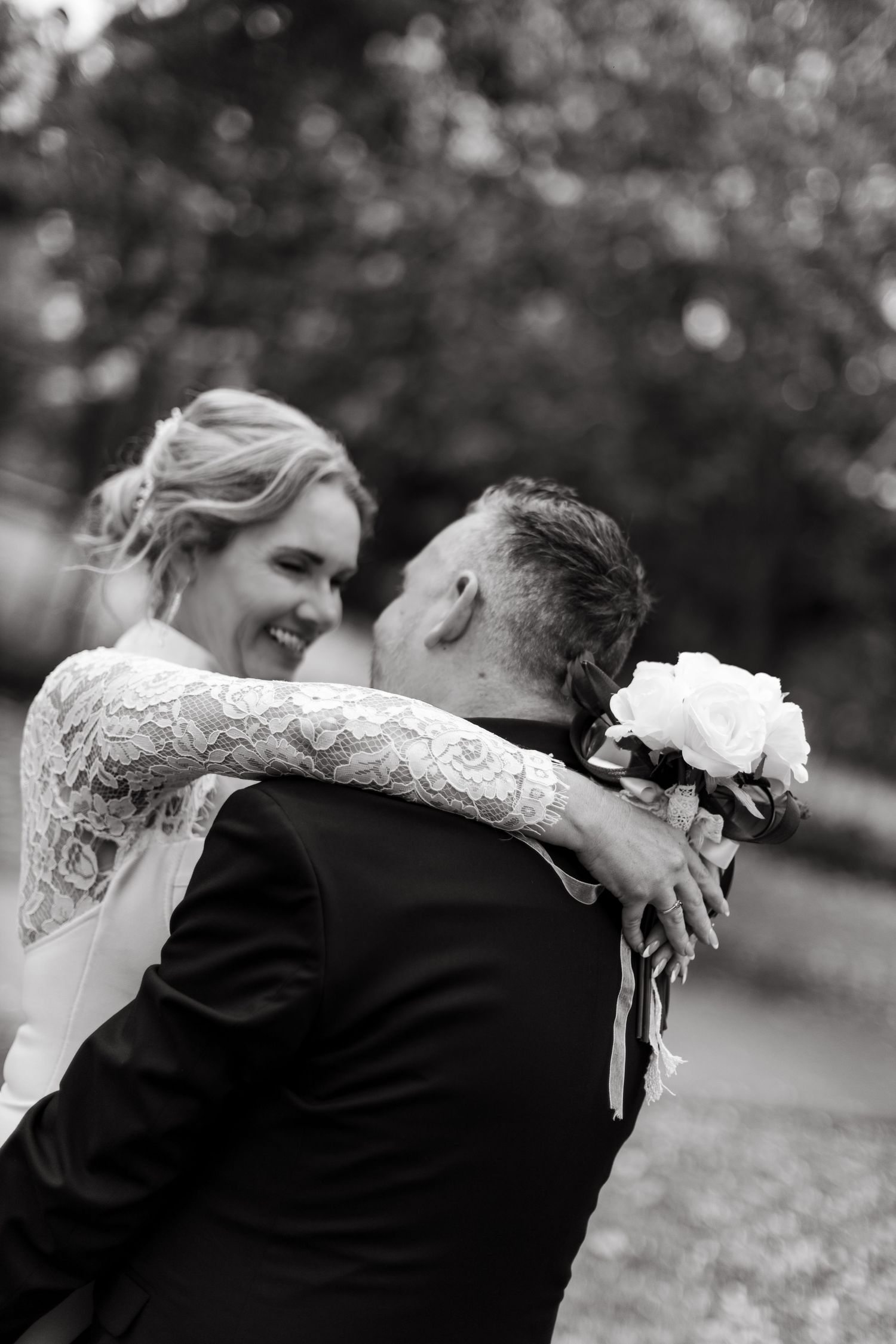 A romantic black and white photo series of a couple embracing and dancing together during their wedding celebration.