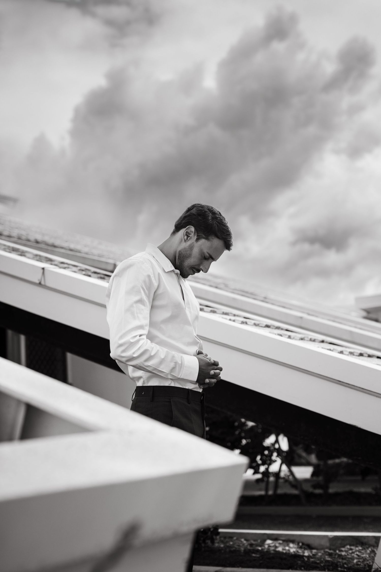 Black and white photos showing dramatic angles of wedding preparations against a cloudy sky.