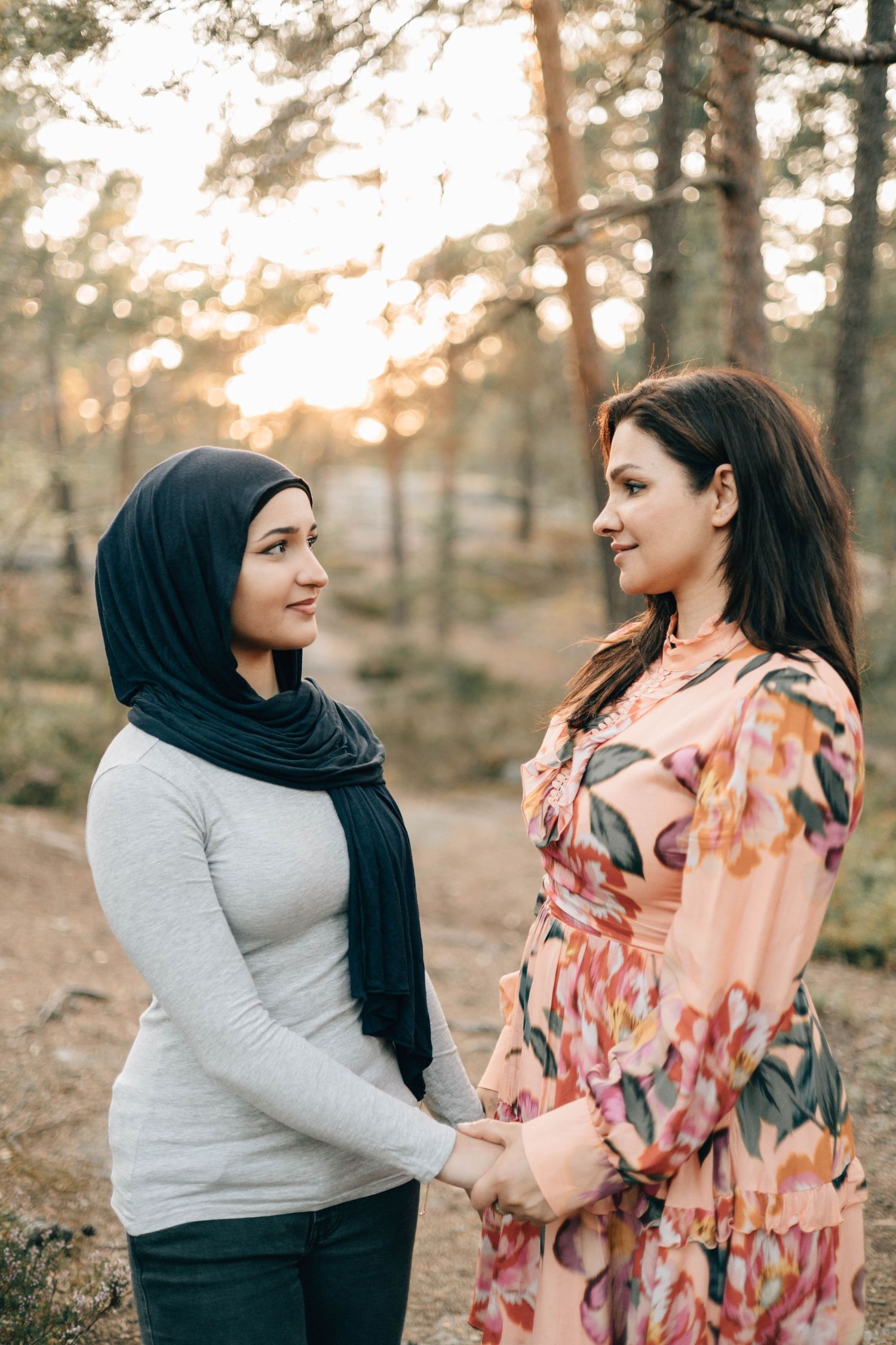 Mamma och tonårsdotter tittar på varandra i skogen.