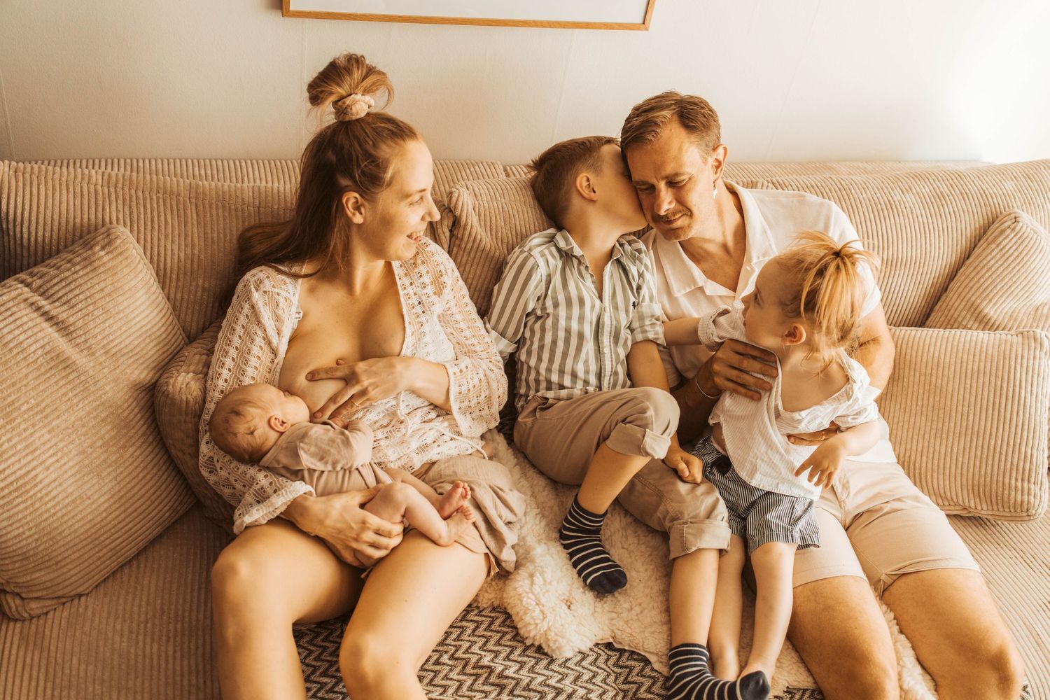 Familjefotografering Stockholm med famil som myser i soffan