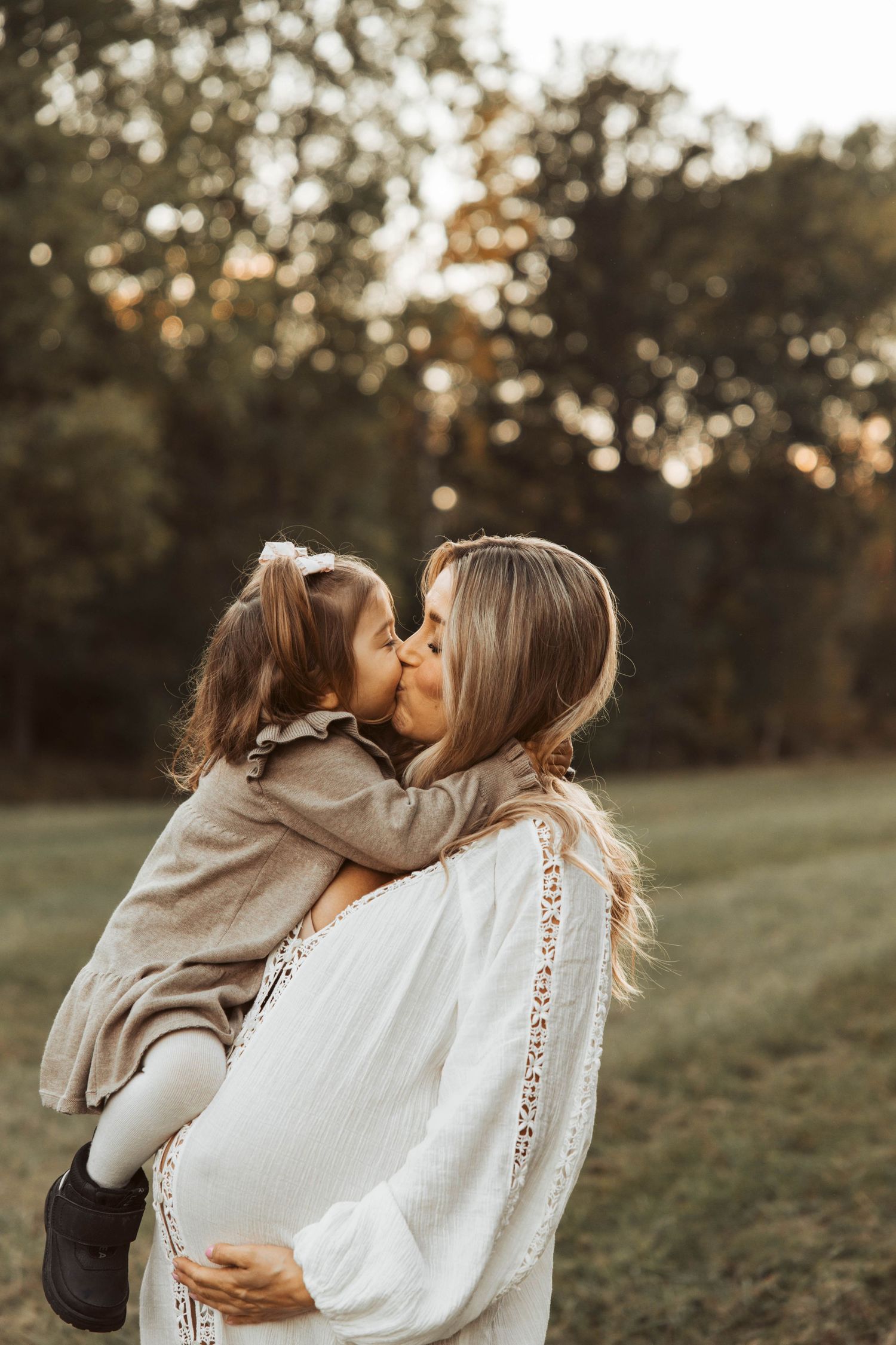 Gravidfotografering med dotter som pussar mamma.