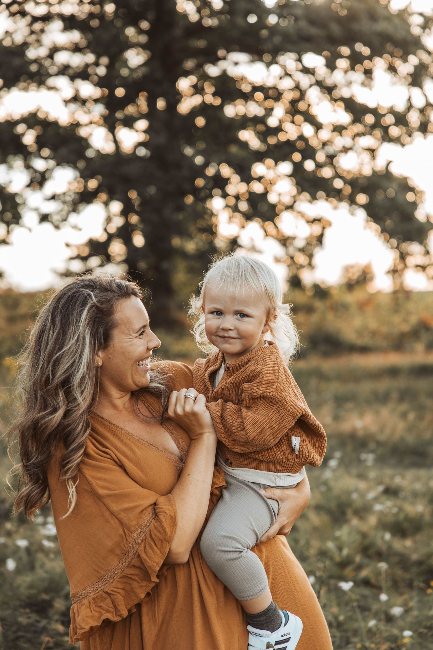 Mamma och son kramar på äng