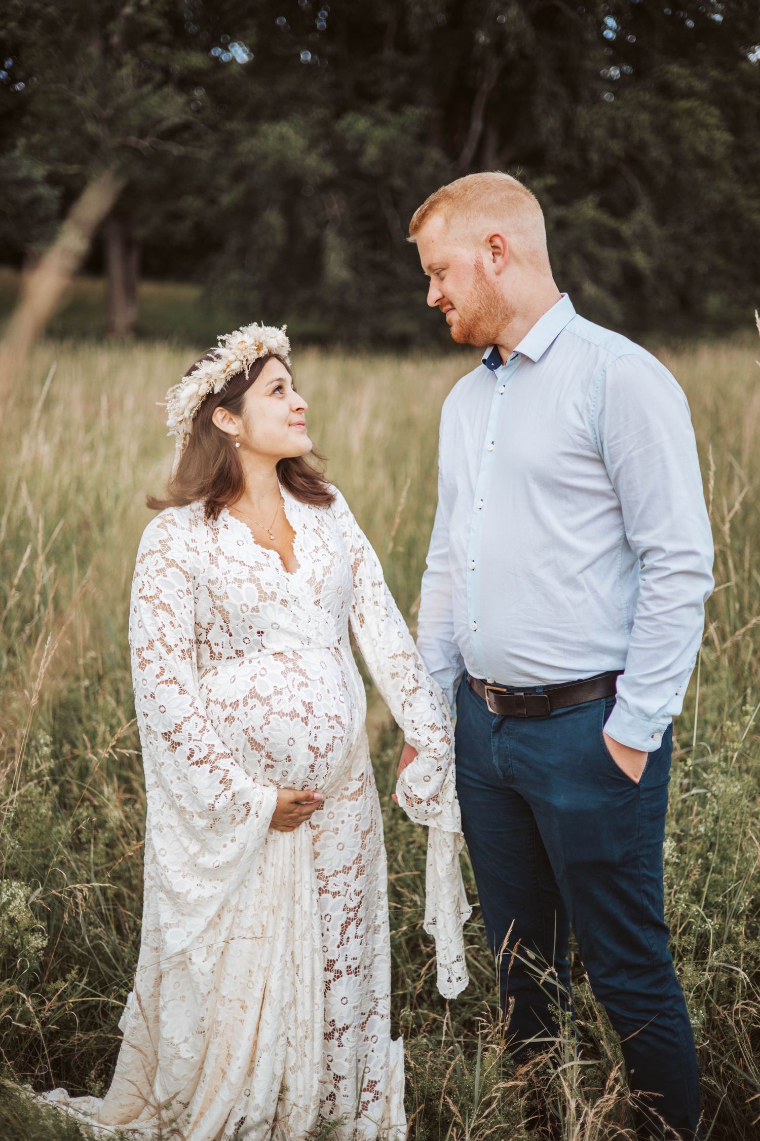 Gravid tittar kärleksfullt på sin partner på en äng.