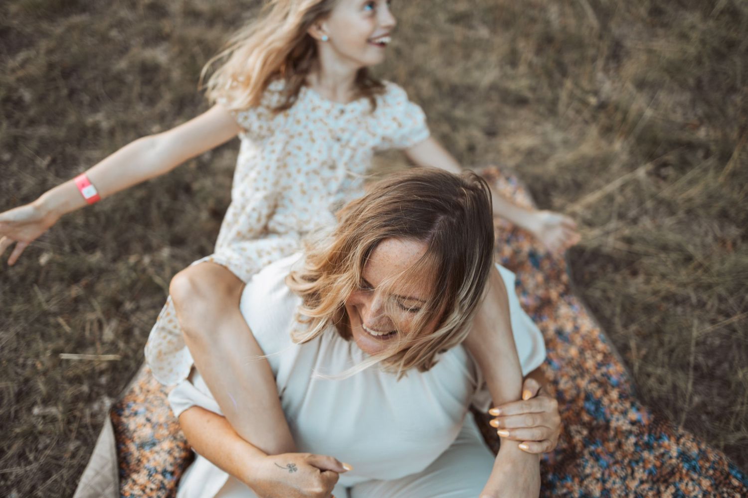 Mamma och dotter myser på en äng och har kul.