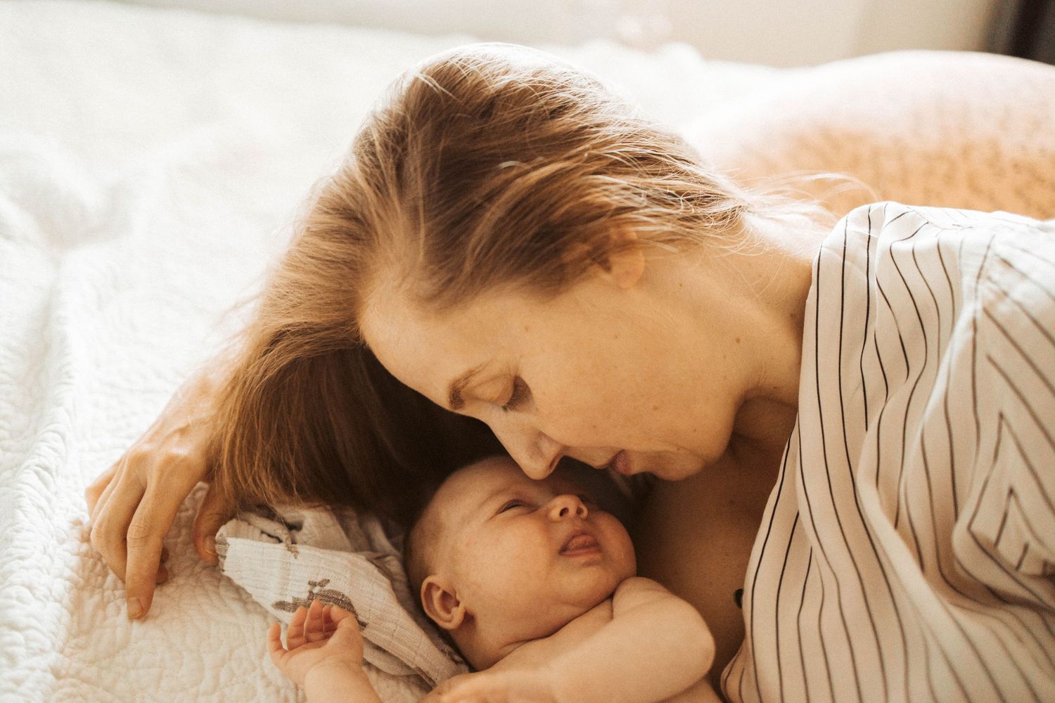 Mamma myser i sängen md nyfödd.