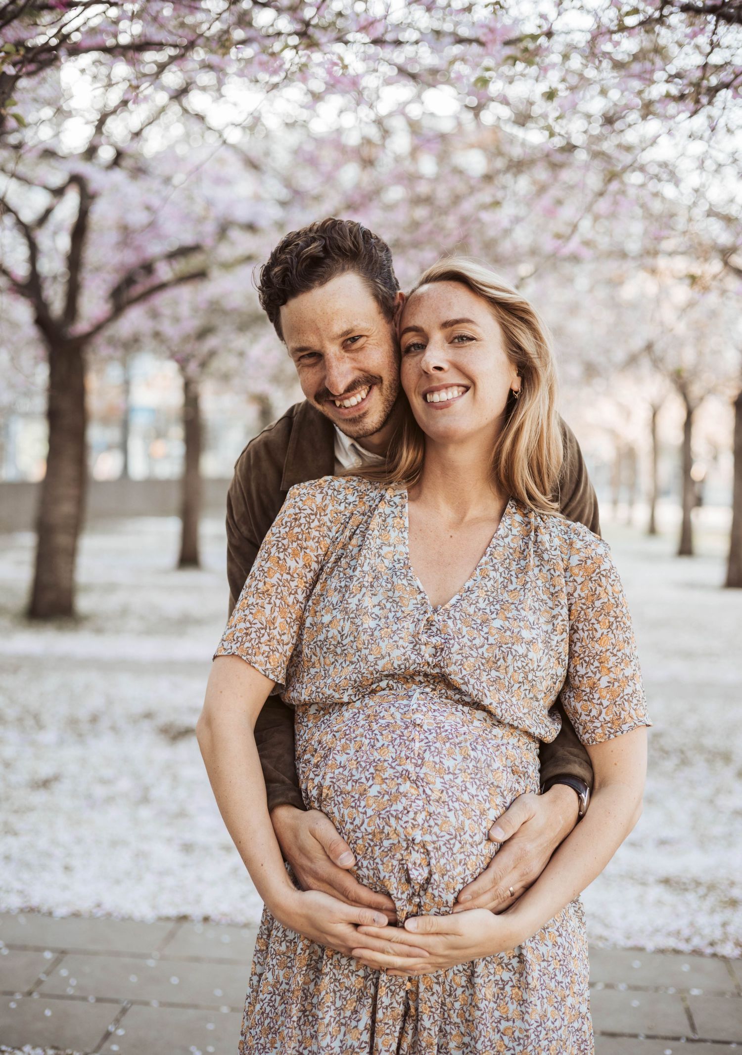 Gravid par myser under körsbärsblommor.