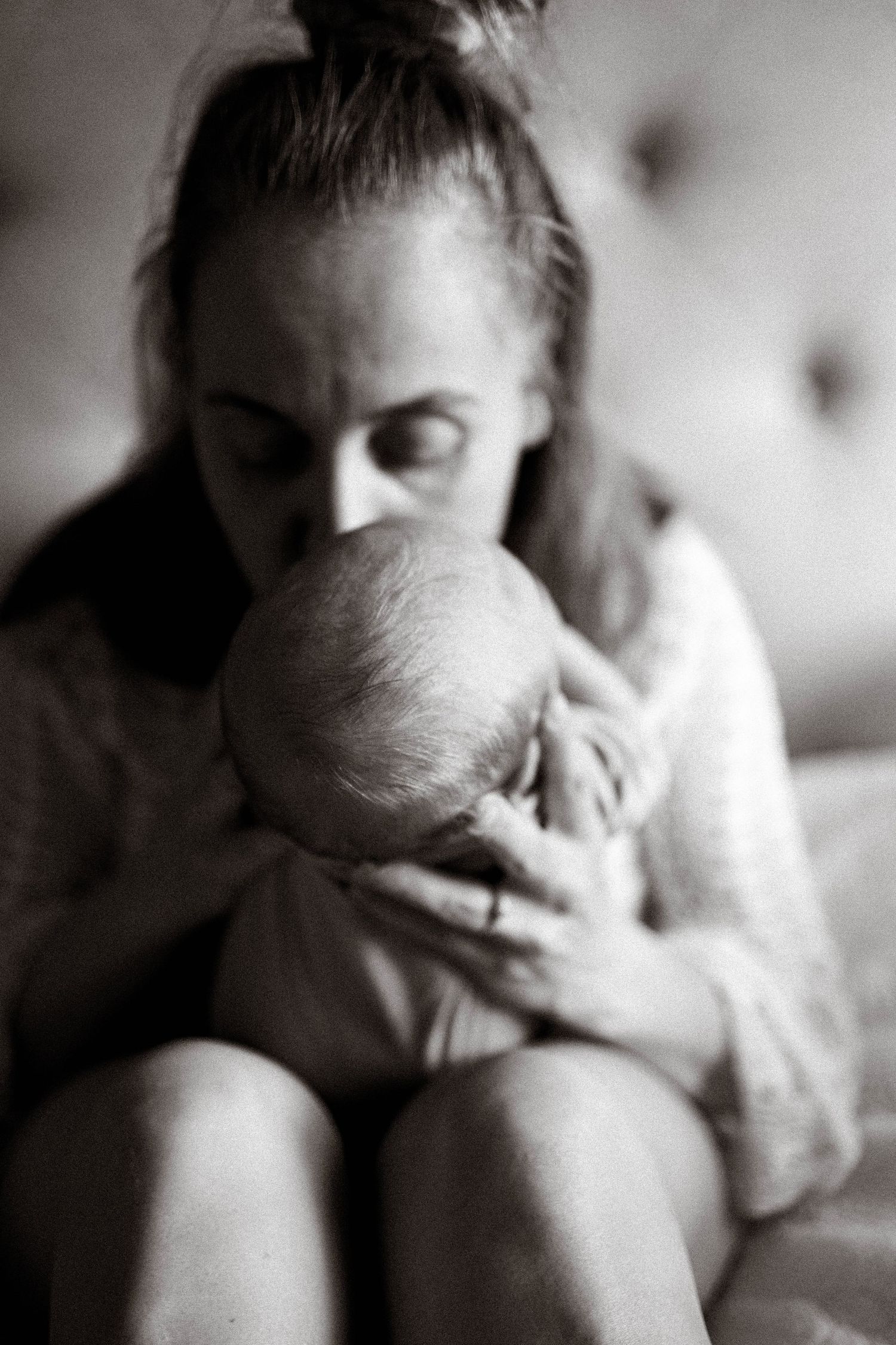 Nyföddfotografering där mamma pussar nyfödd bebis.