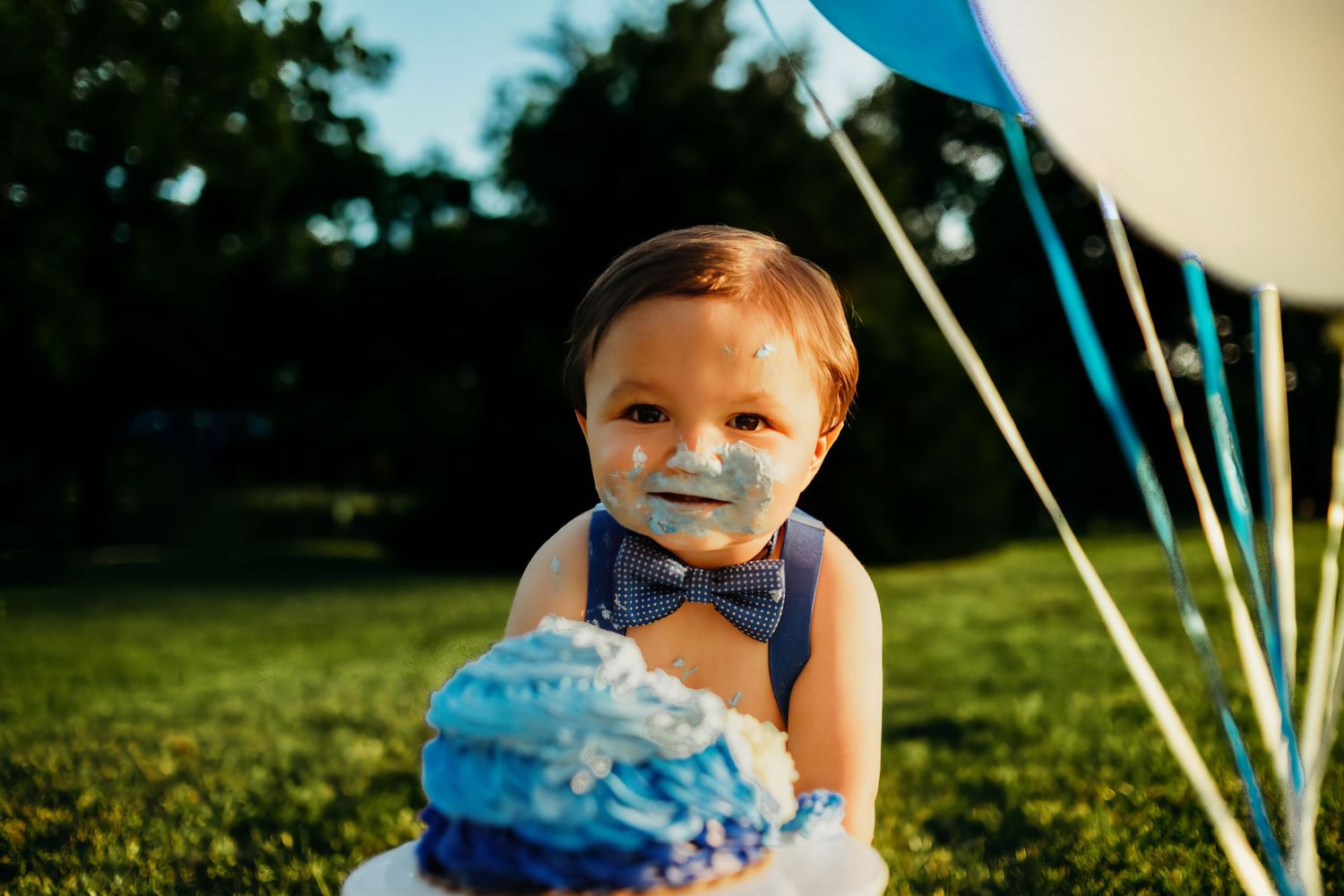 Outdoor celebration scene with blue balloons and natural lighting.