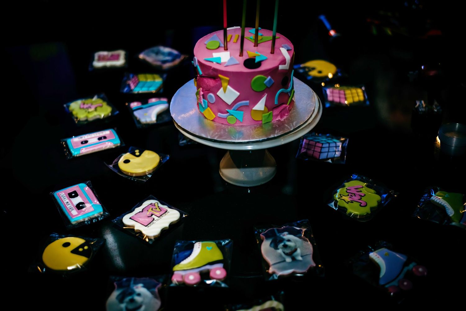 Birthday party table setup with colorful cake and decorations.