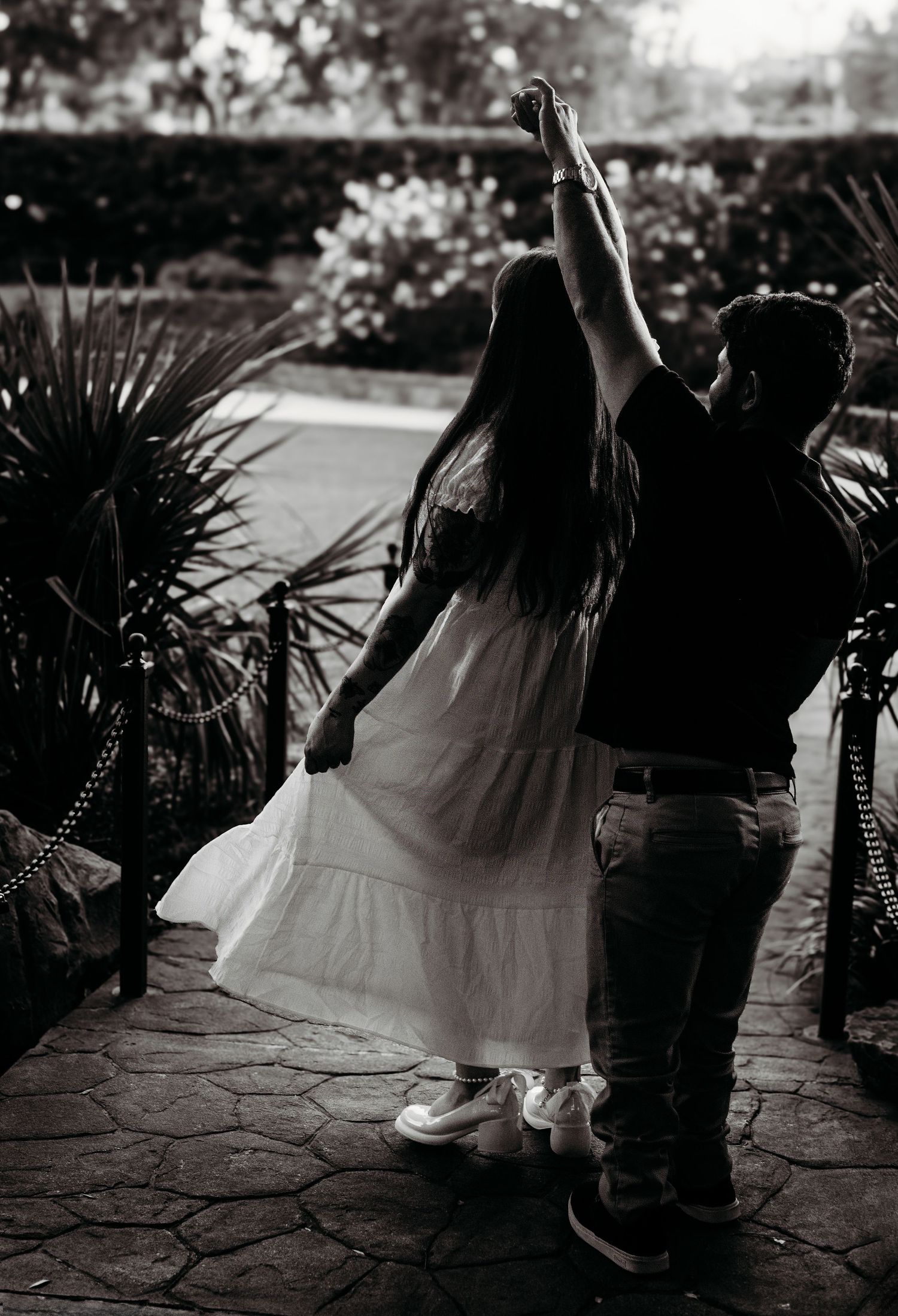 Black and white photo series of romantic dance movements on stone patio.