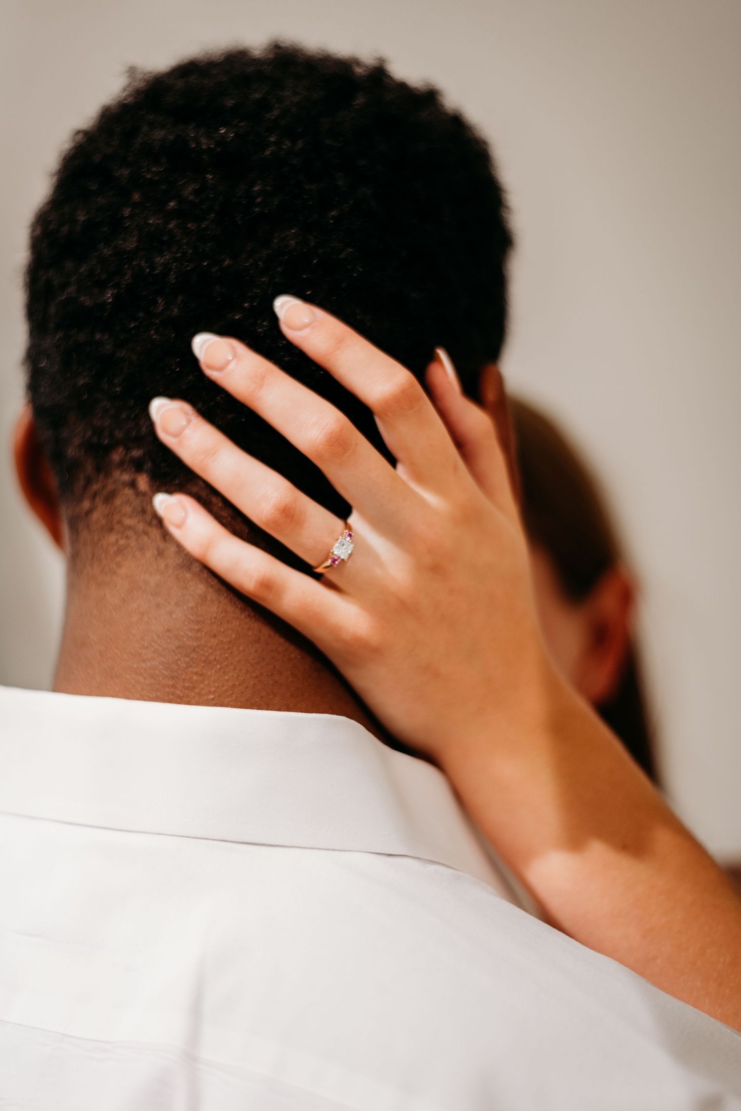 Artistic close-up sequence showing hands with engagement ring against dark hair and white clothing.