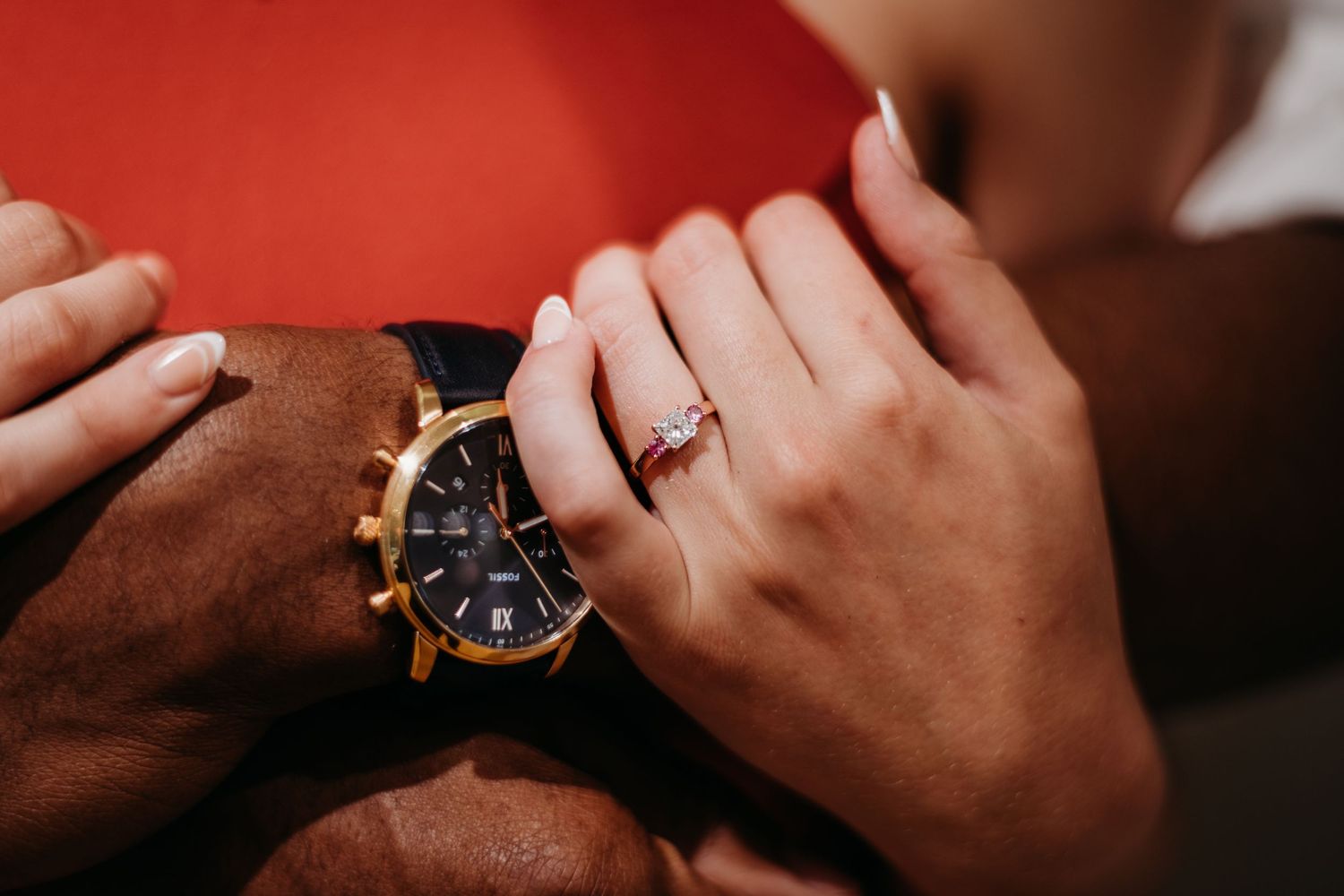 Close-up detail shot of hands with jewelry and warm lighting.