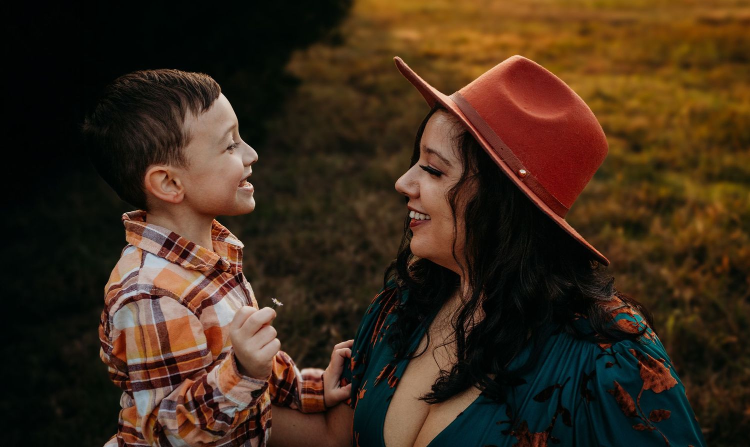 A joyful moment captured in warm sunlight with a brown fedora and plaid shirt.