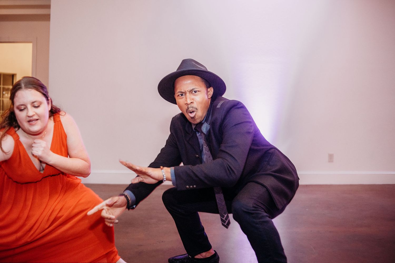 Artistic photo series of performers in orange and black clothing on a studio floor.