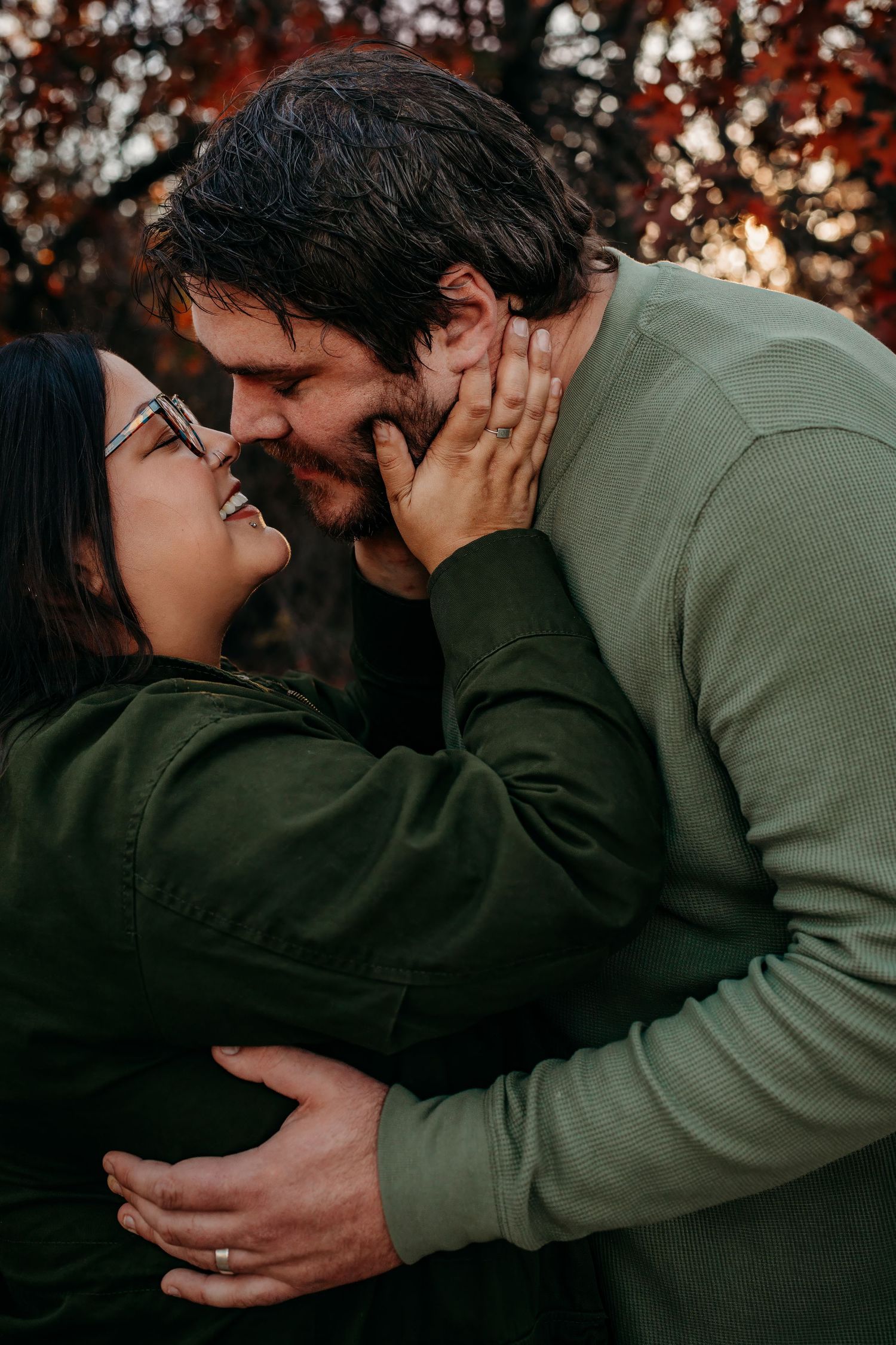 A romantic couple shares an intimate moment outdoors during golden hour.