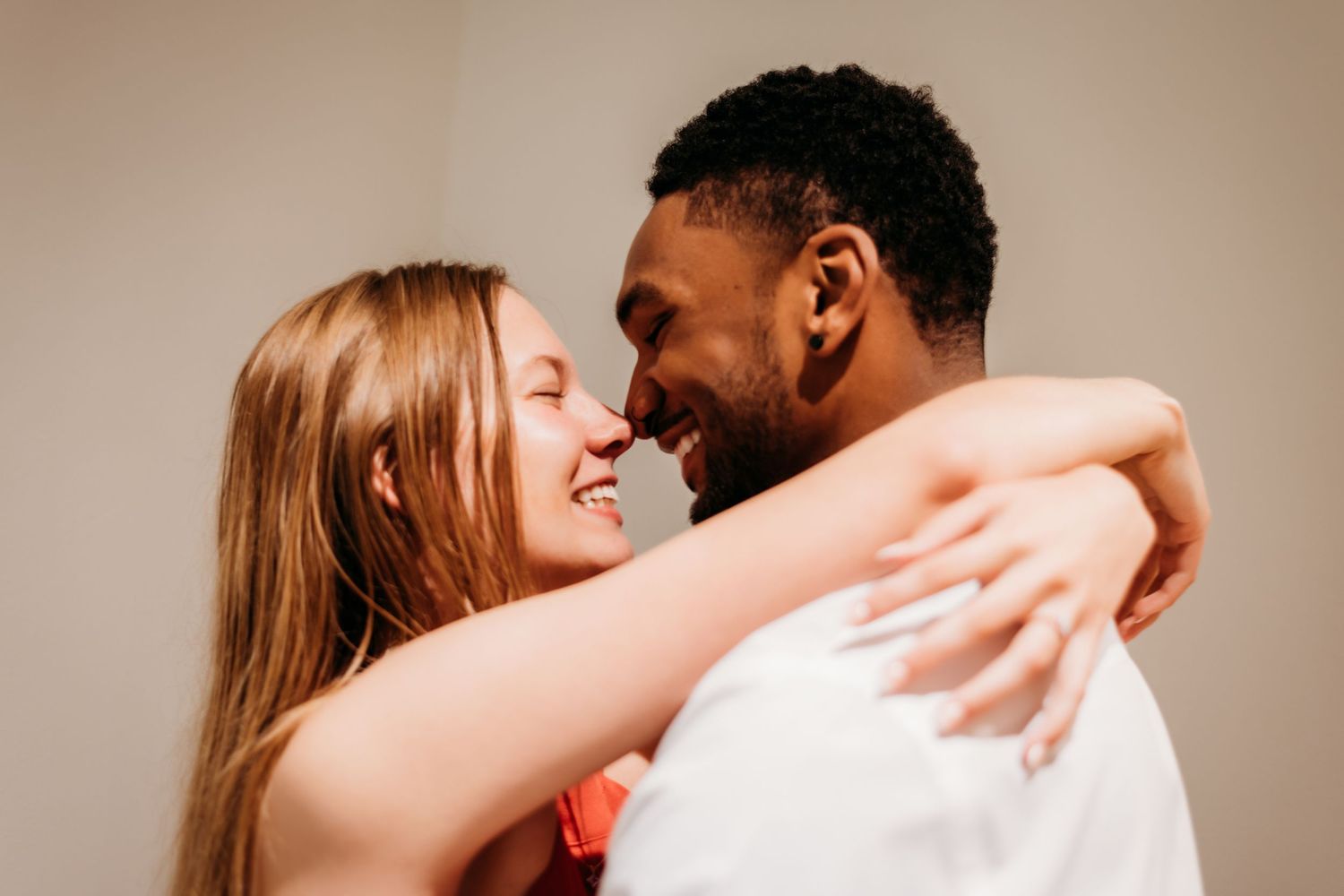 Intimate romantic sequence showing a tender embrace against a neutral background.