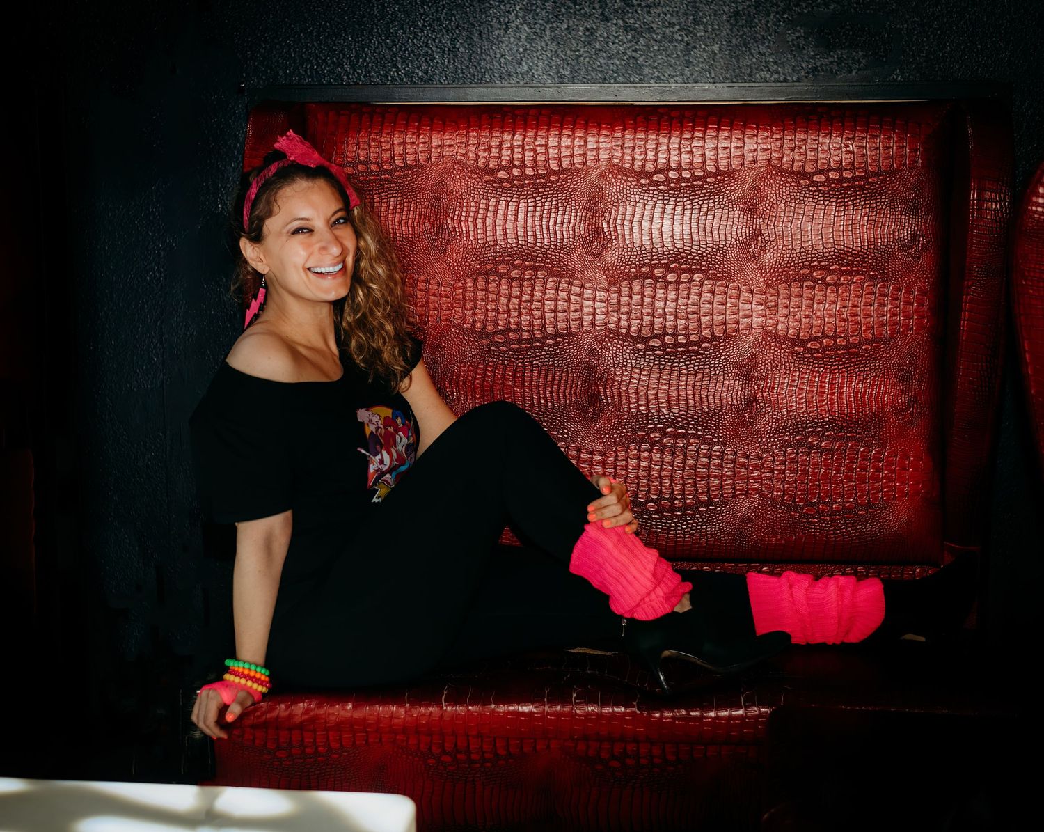 Dramatic red leather booth seating in dark ambient lighting.