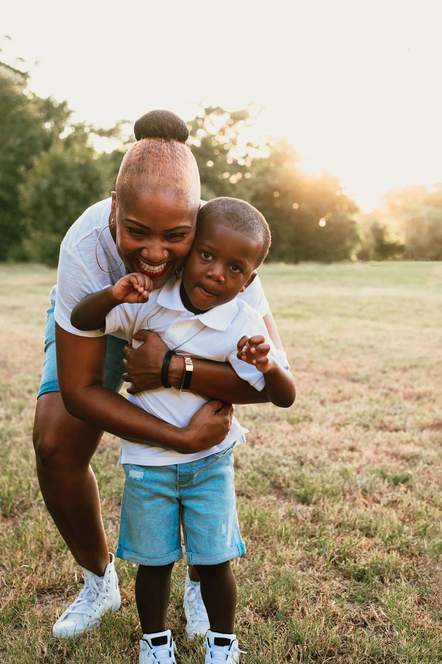 A playful moment captured between parent and child outdoors at sunset.
