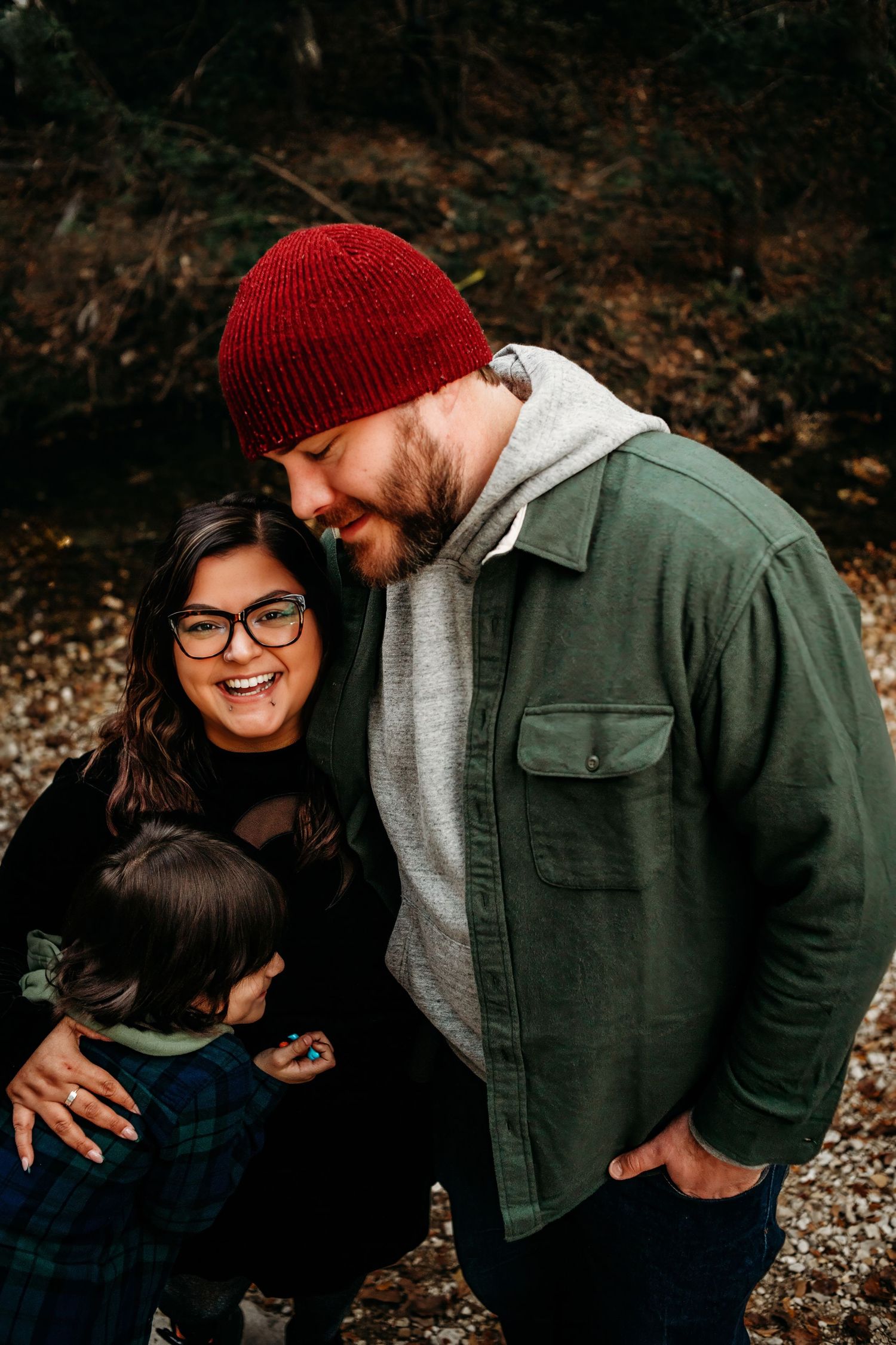 Couple sharing intimate moments outdoors wearing winter attire and casual clothing.