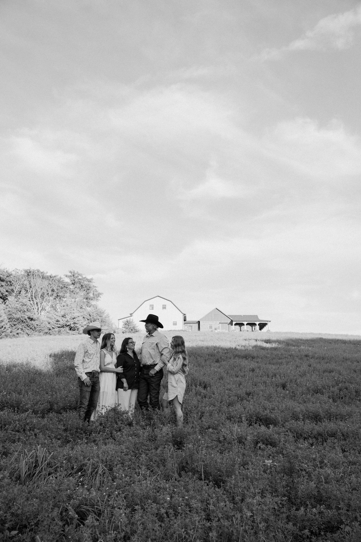 Group walking through a grassy field on an overcast day in black and white.