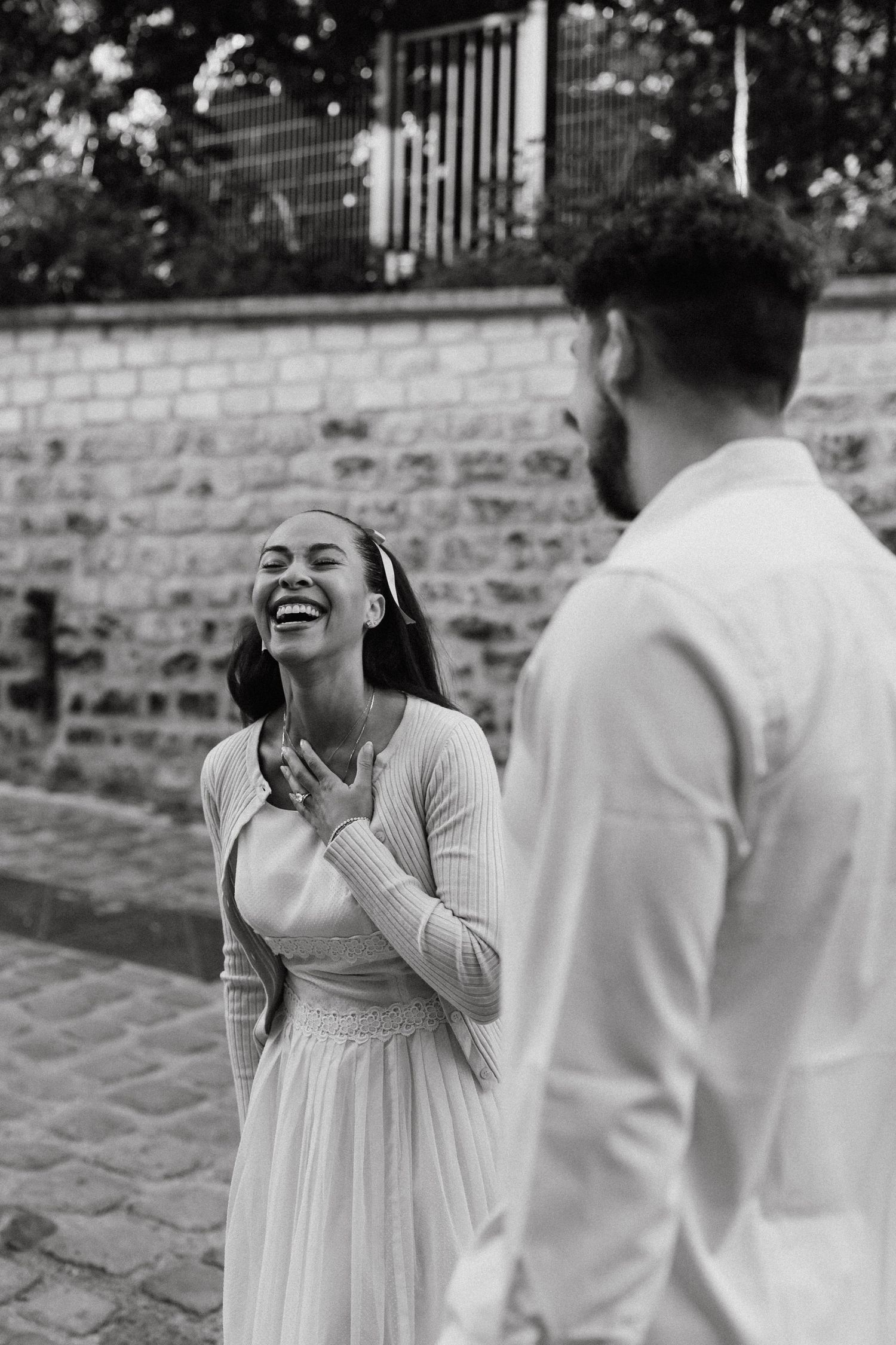 Black and white photo sequence showing a joyful couple laughing together during an outdoor photoshoot.