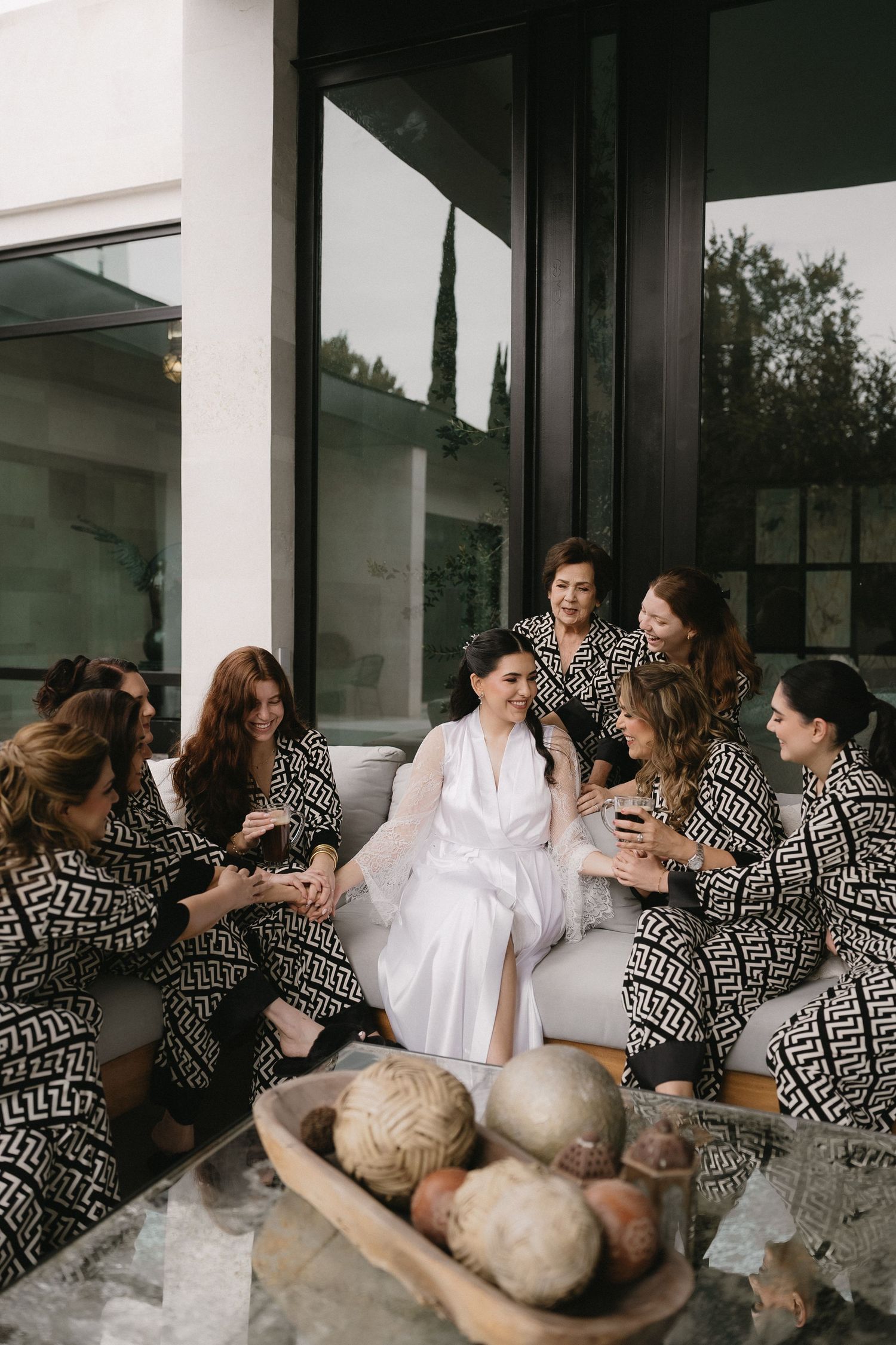 A group wearing matching black and white geometric prints gathers on a modern porch.