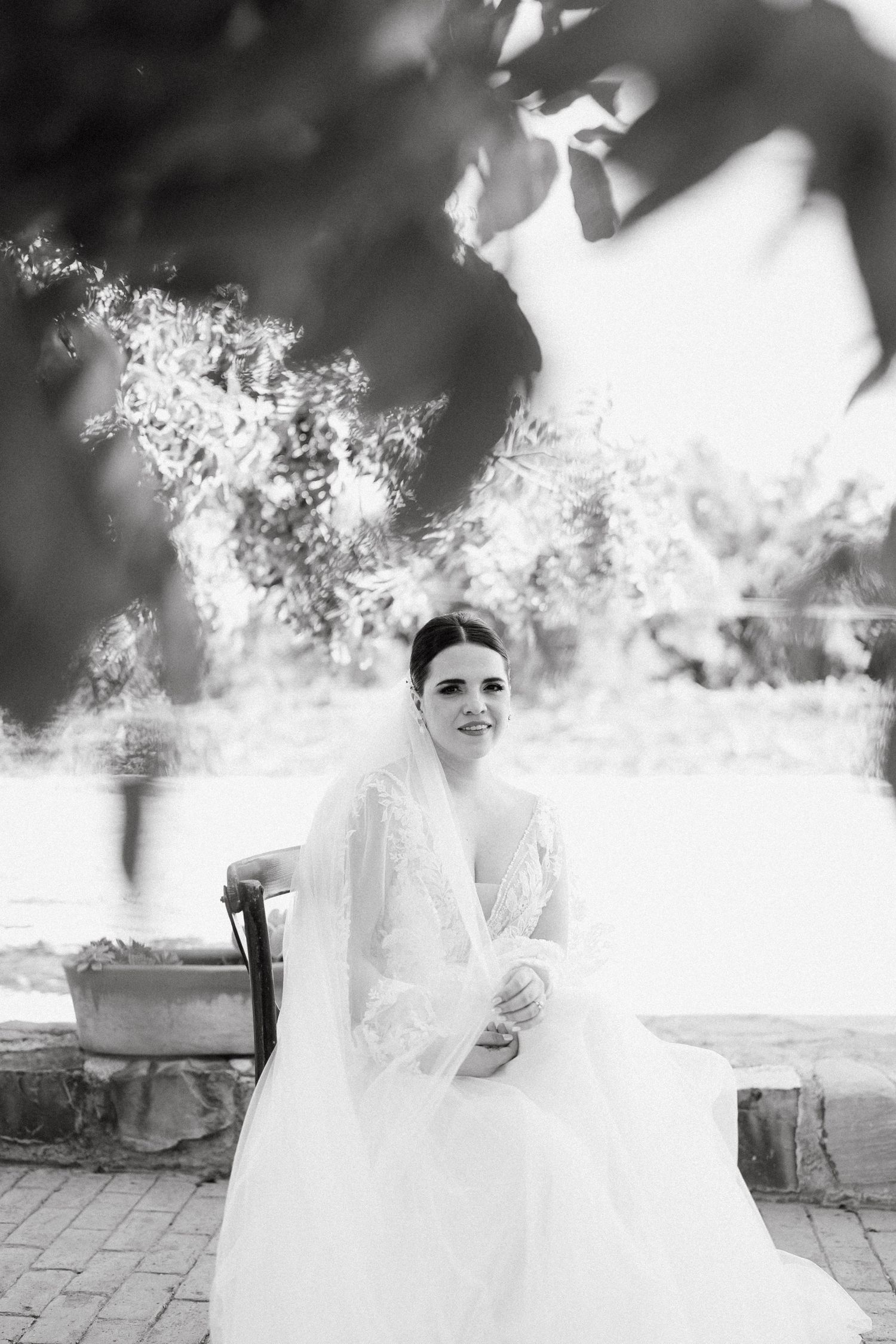 Ethereal black and white portrait through delicate foliage.