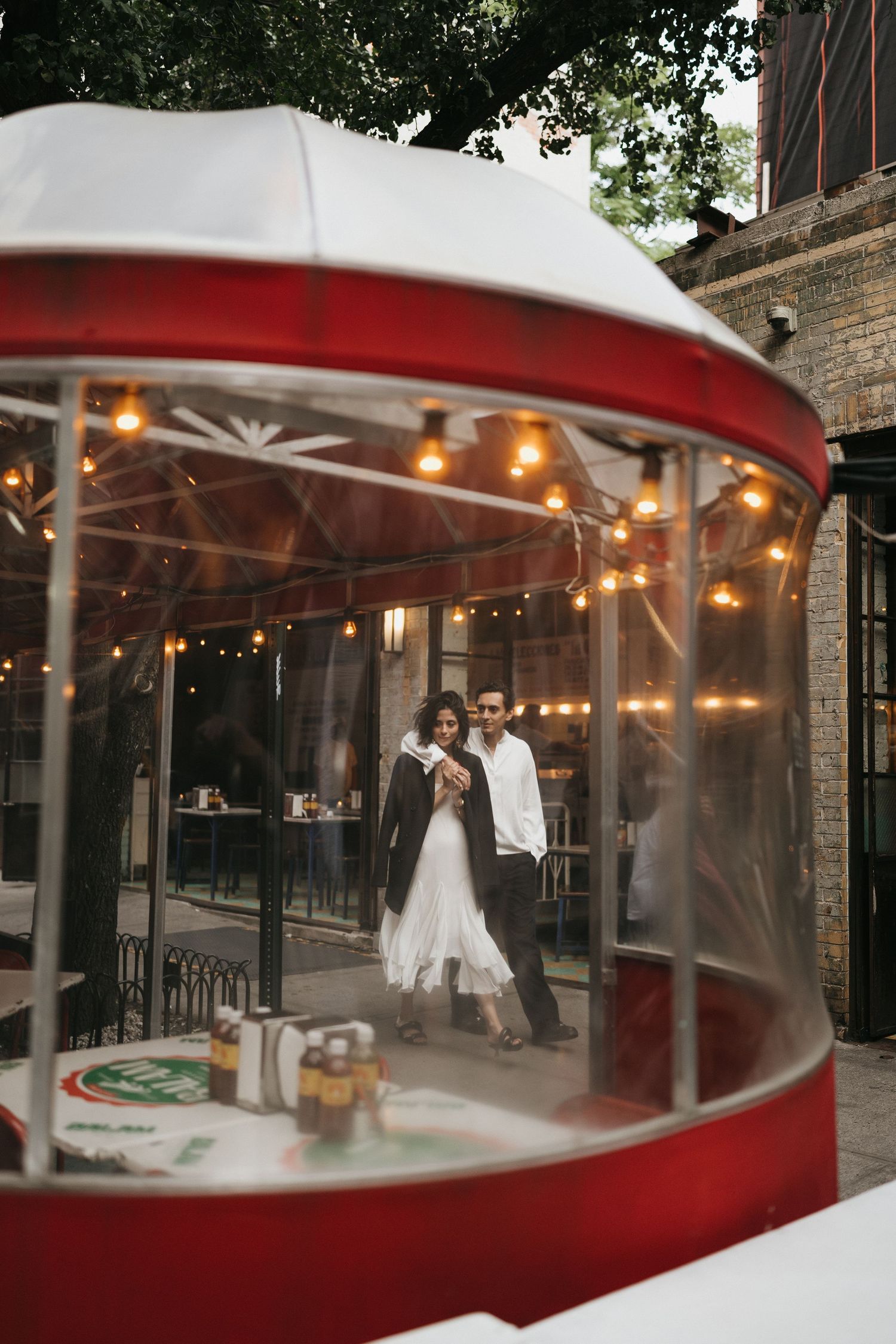 Red and white outdoor dining area with string lights and covered seating.