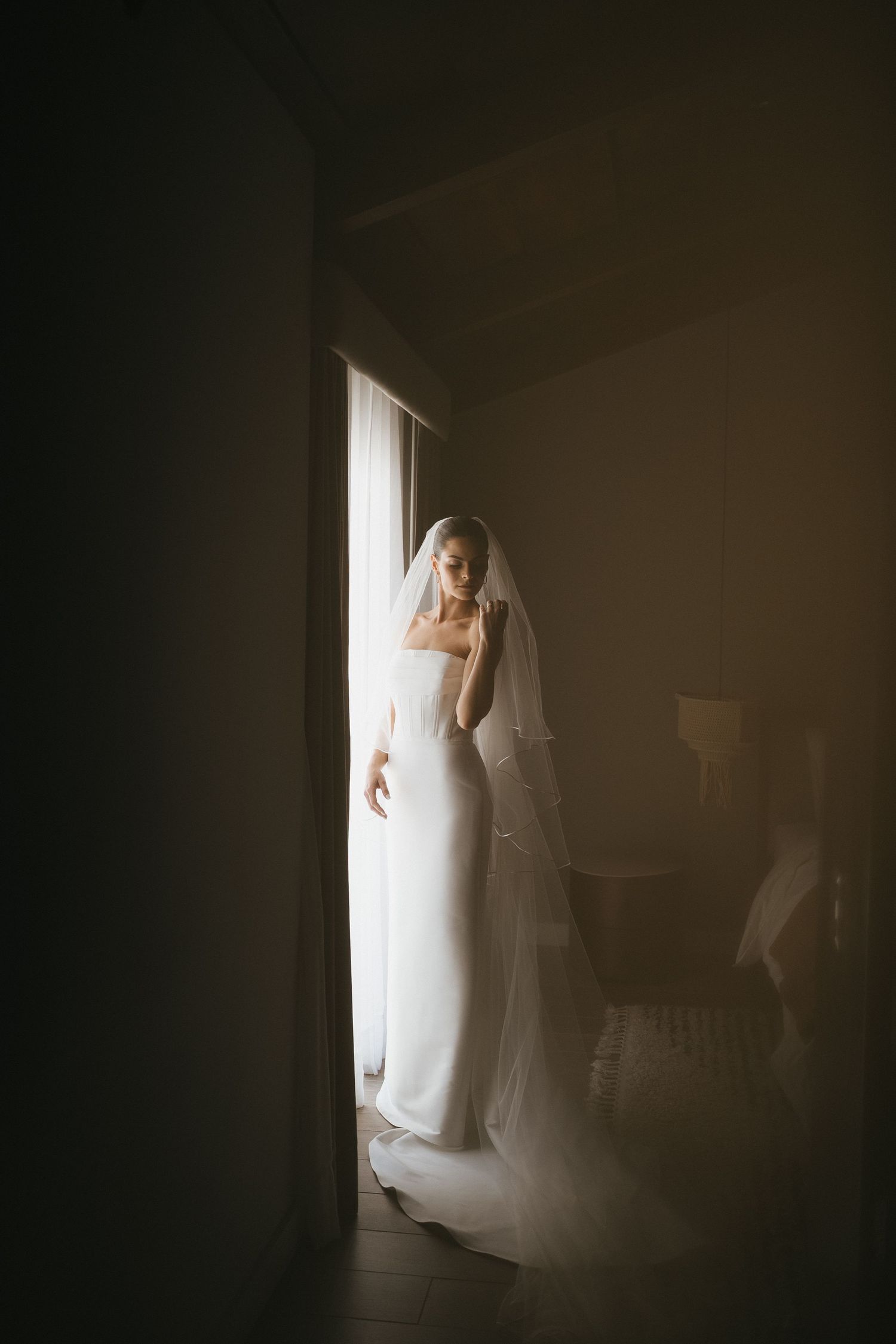 Artistic silhouette of flowing white fabric against dark background with dramatic lighting.