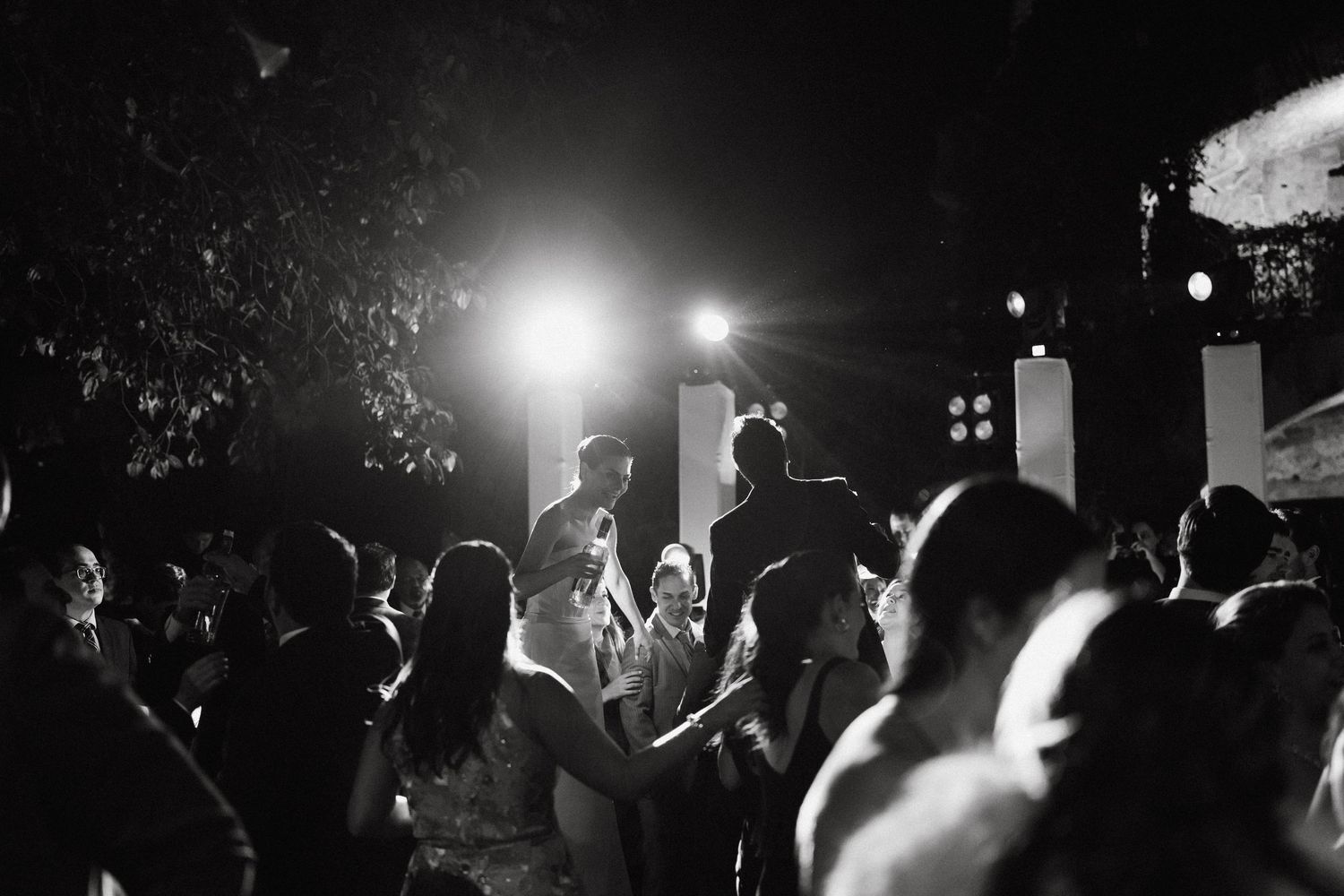 Black and white photos of a nighttime wedding reception with dancing silhouettes.
