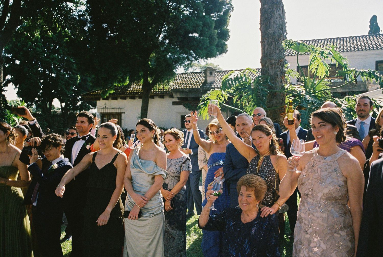 Guests enjoy drinks and conversation at an outdoor garden party.