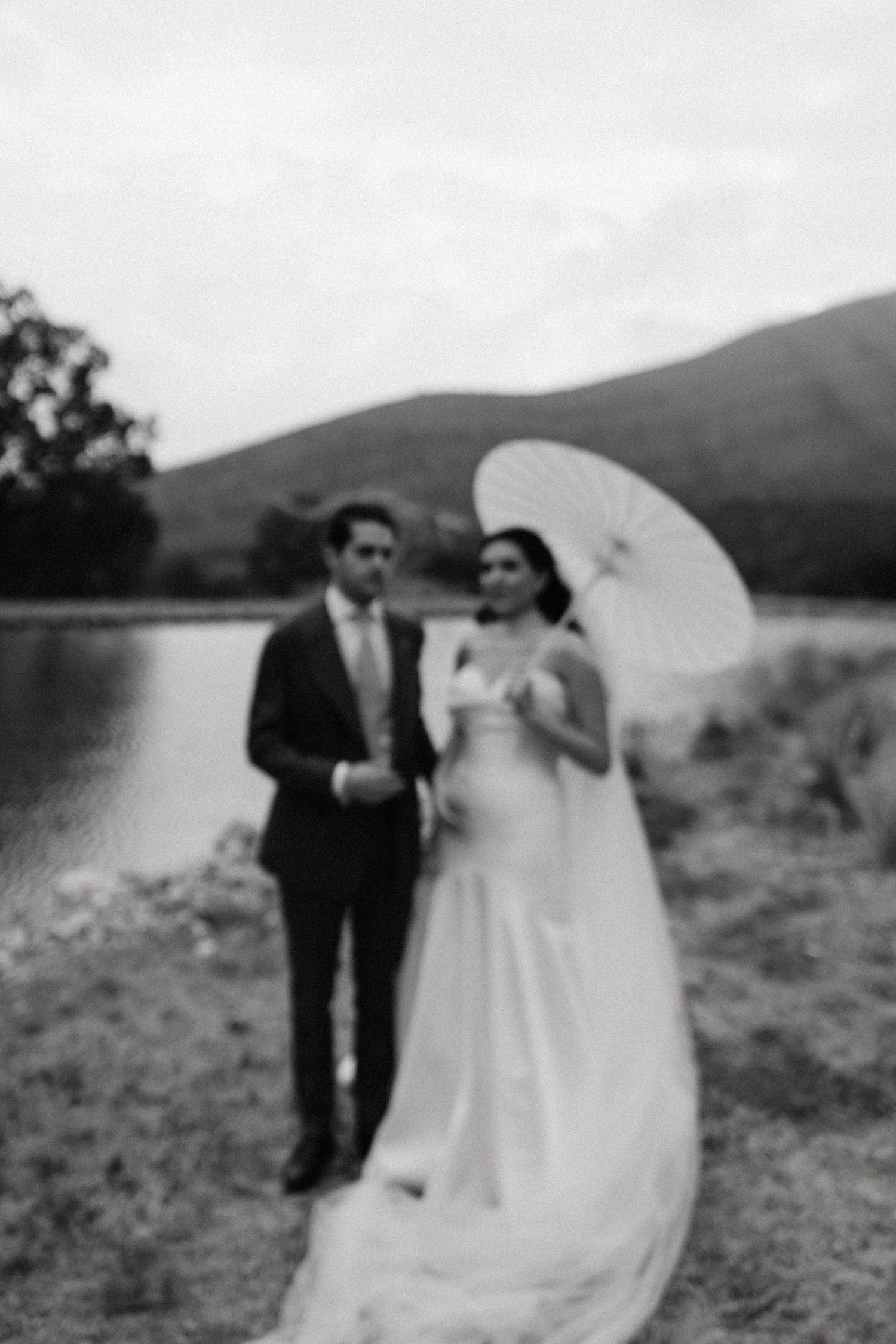Wedding couple walking together in a desert landscape with mountains in the background.