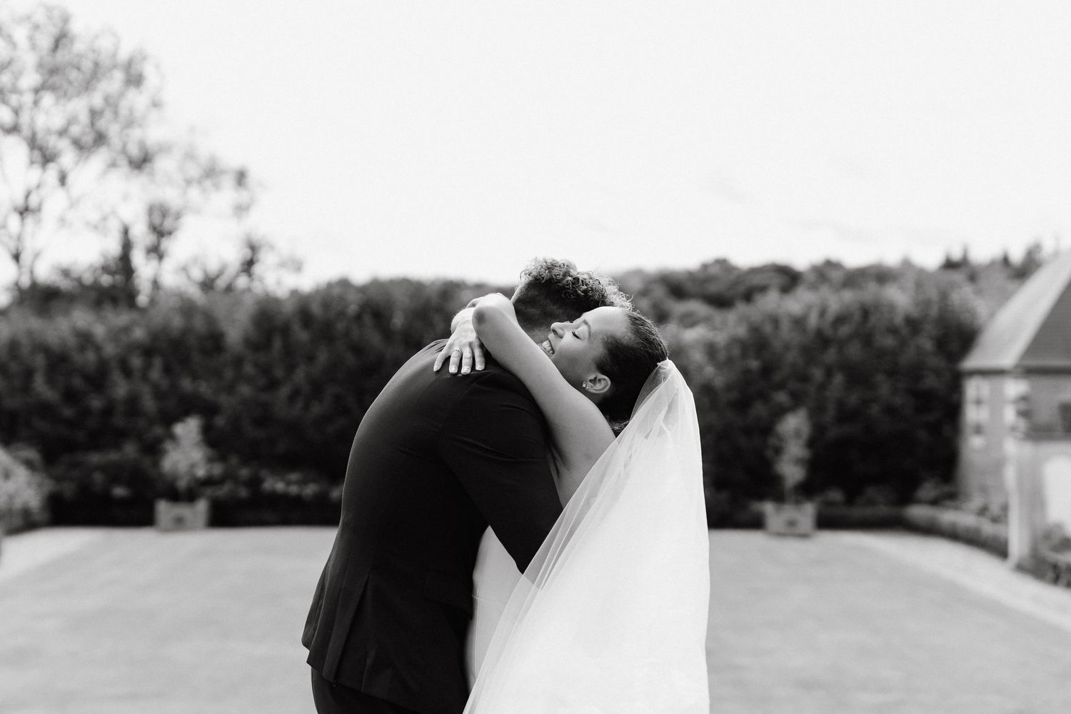 A series of black and white romantic wedding photos showing a couple embracing outdoors.