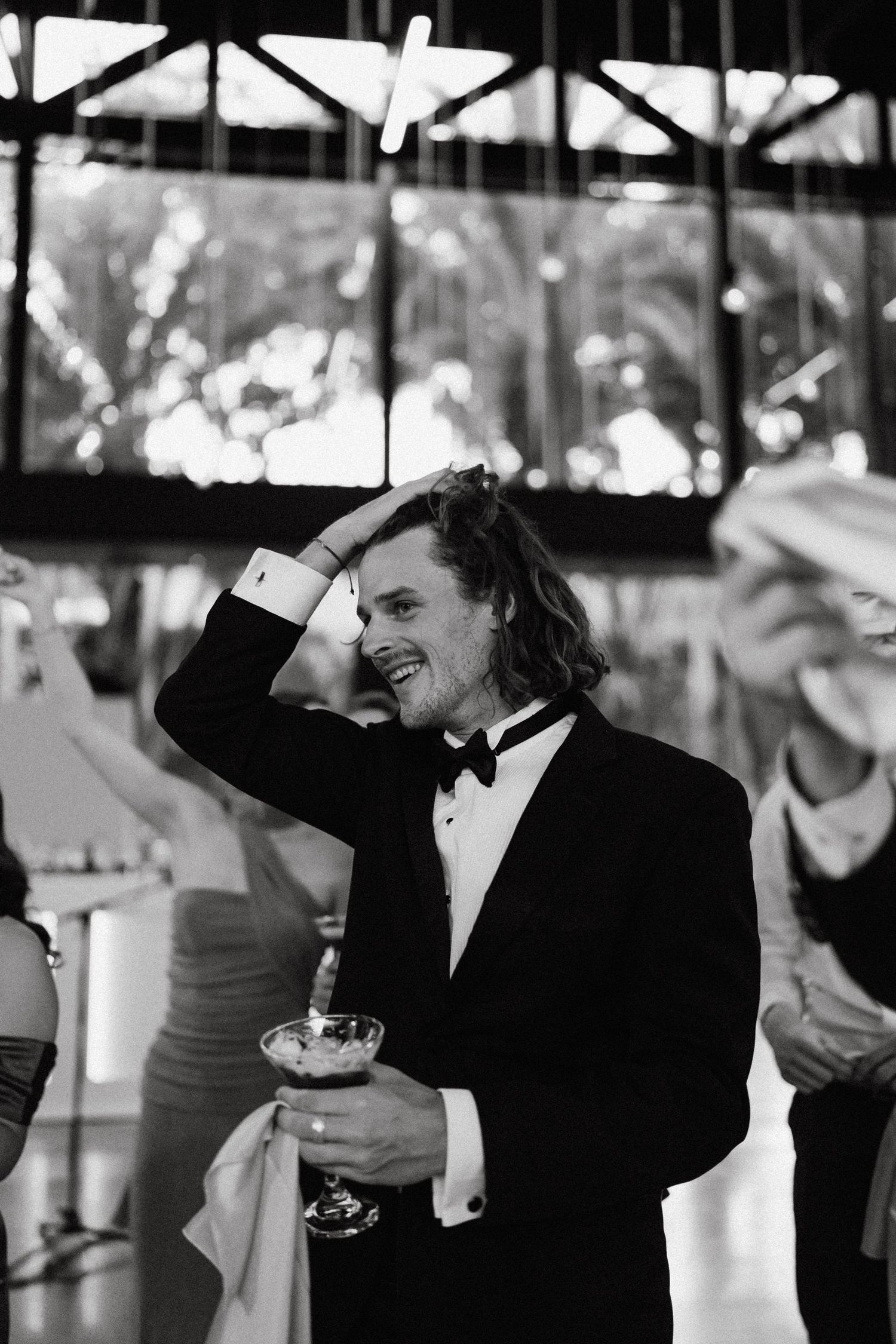 People enjoying drinks at an outdoor event venue in black and white.