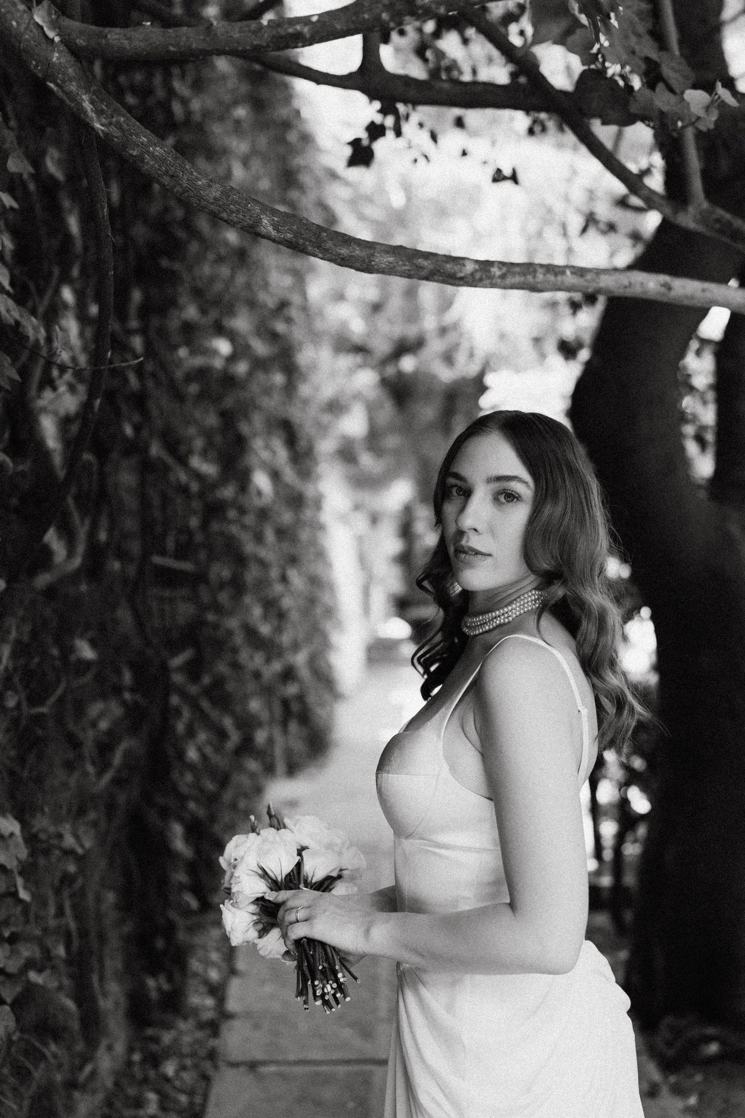 Black and white bridal portraits taken under tree branches with natural lighting.
