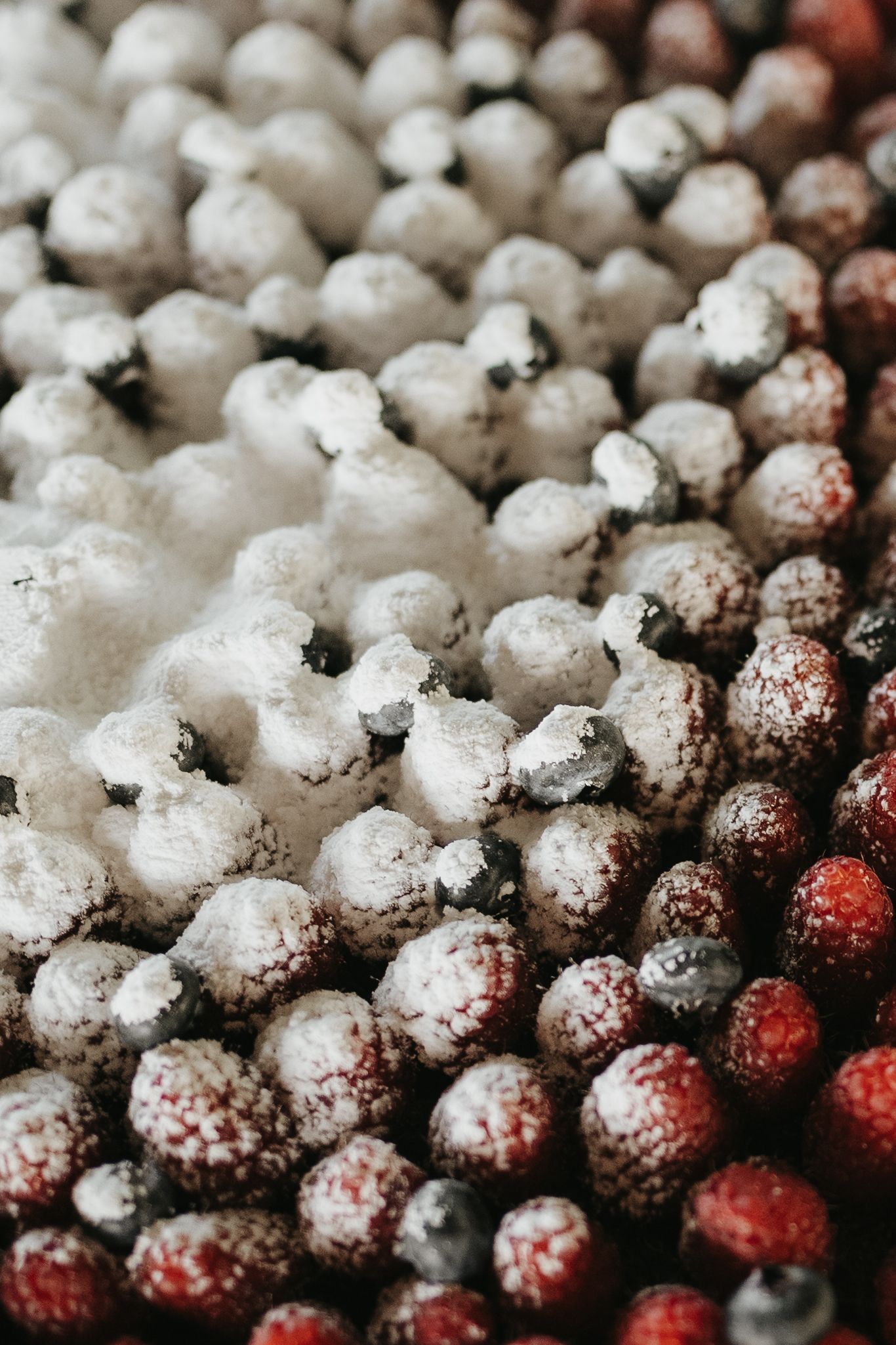 Macro shot of frozen raspberries covered in frost and ice crystals.
