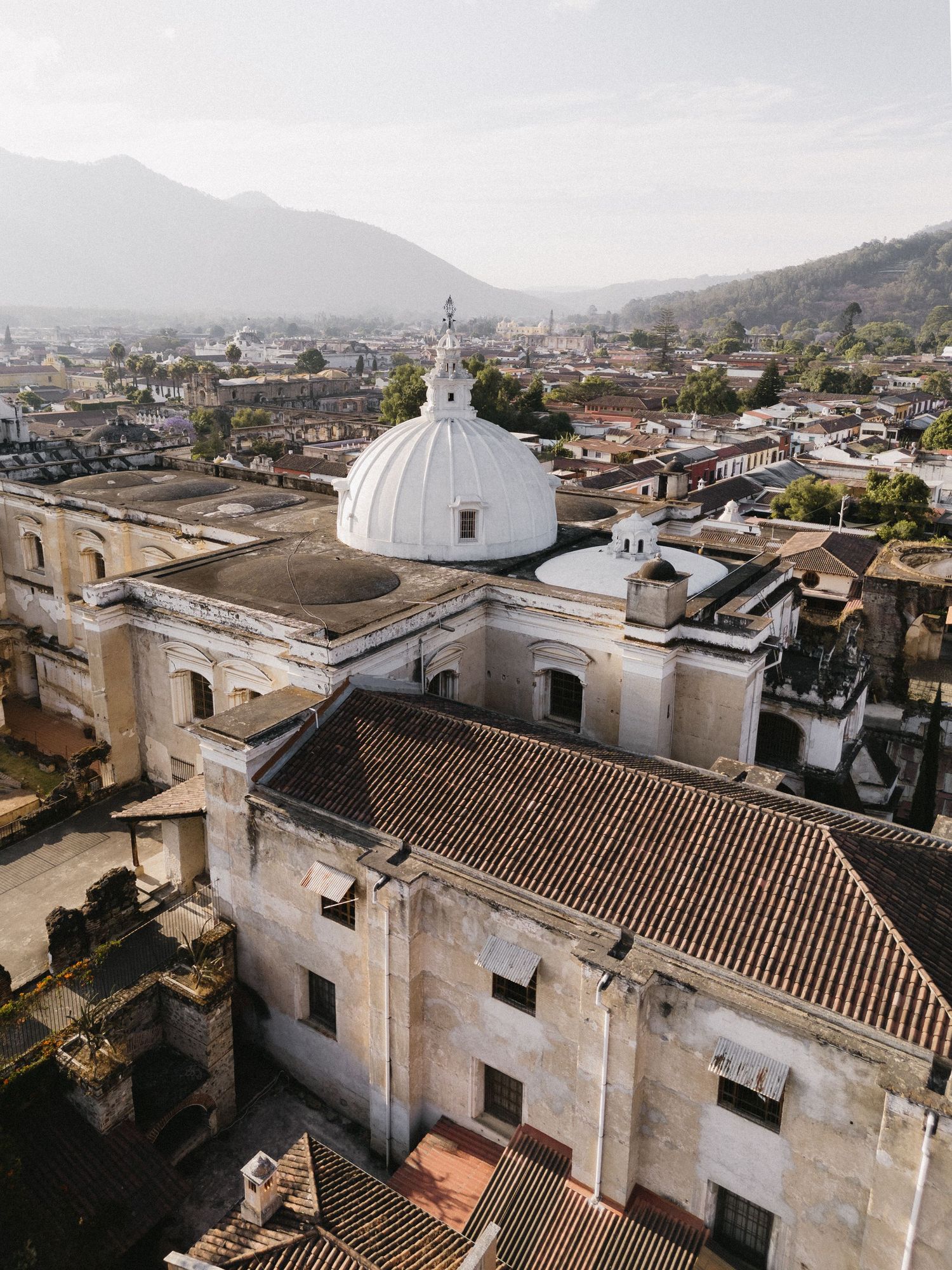 Colonial architecture with white church buildings and terracotta roofs in a historic Latin American town.