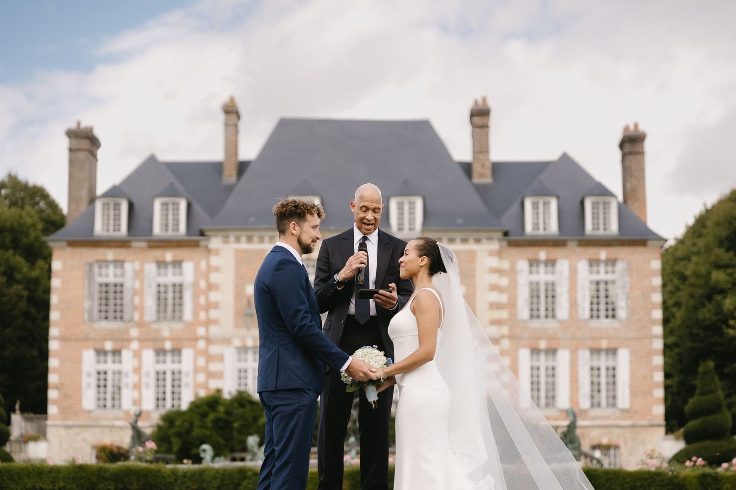 A wedding celebration at a grand French chateau with elegant architecture and manicured grounds.