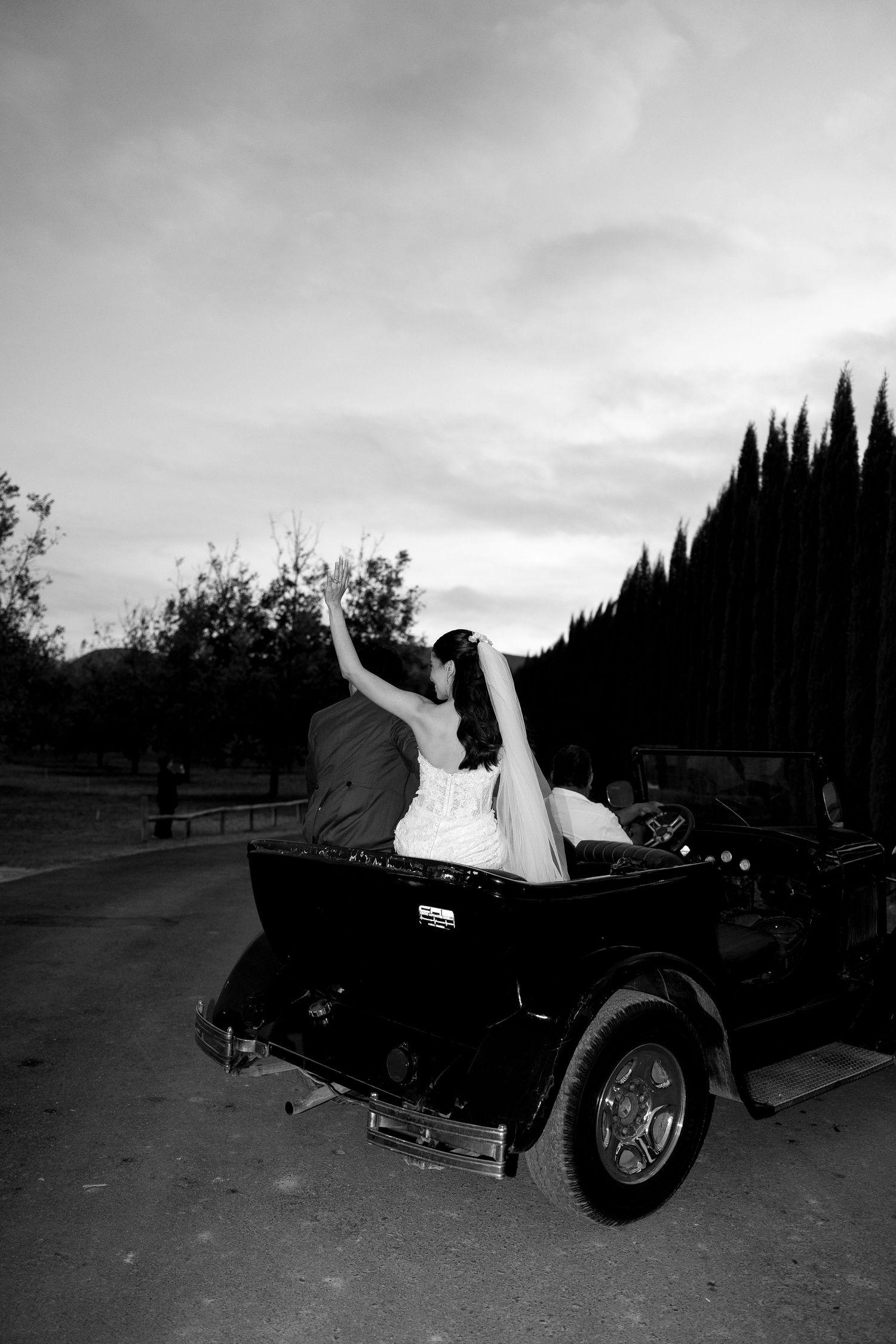A black and white photo series shows someone reclining dramatically across a vintage car in four sequential poses.
